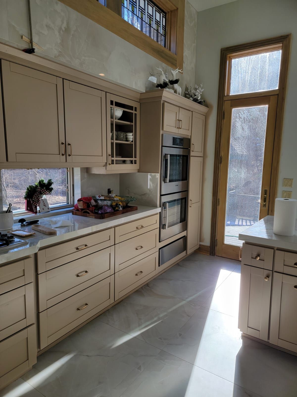 A kitchen with a lot of cabinets and drawers and a window.