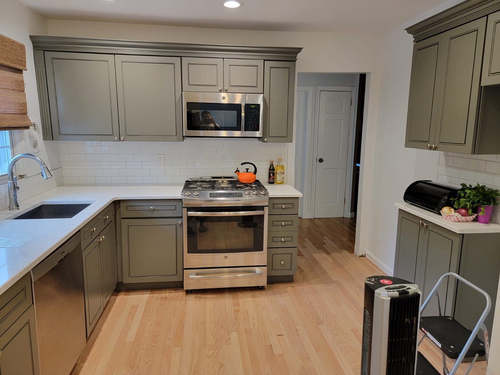 A kitchen with gray cabinets and stainless steel appliances