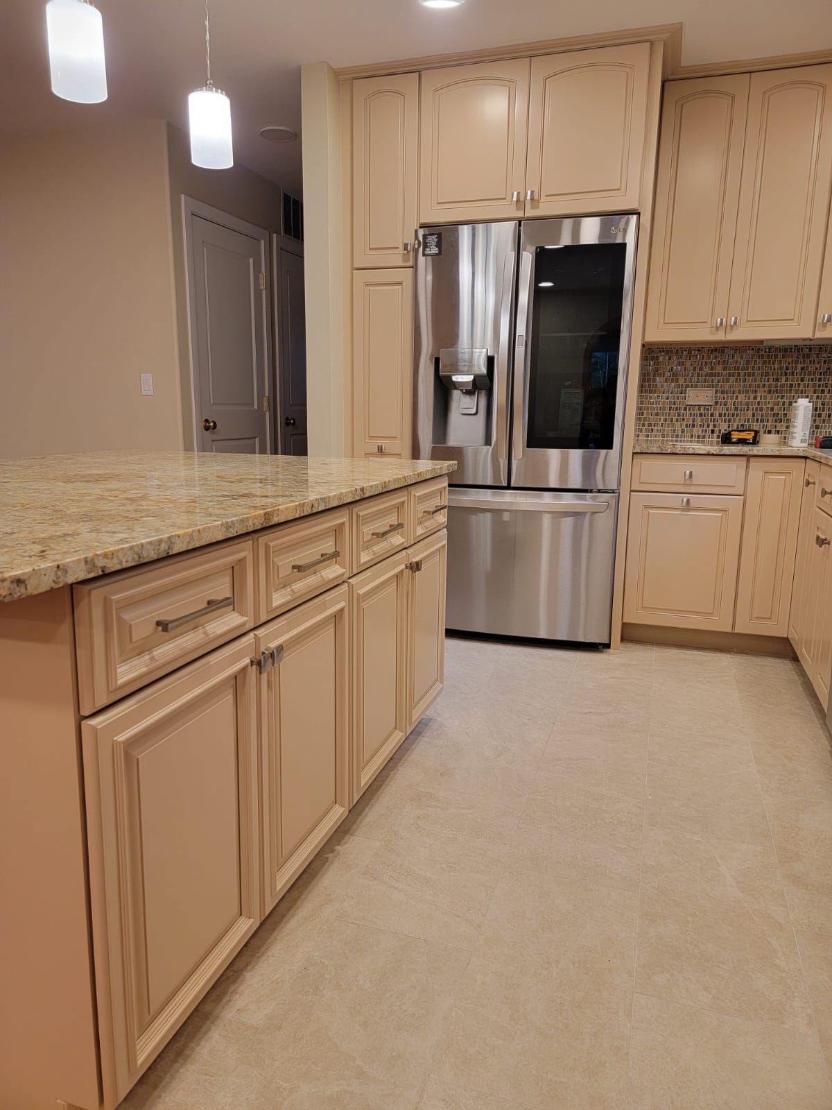 A kitchen with stainless steel appliances and beige cabinets