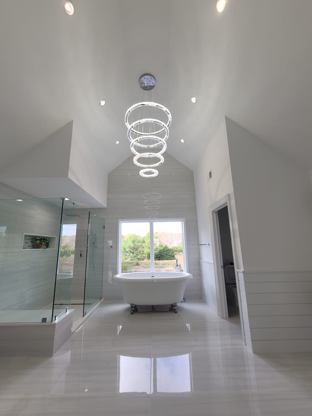 A bathroom with a bathtub and a chandelier hanging from the ceiling.