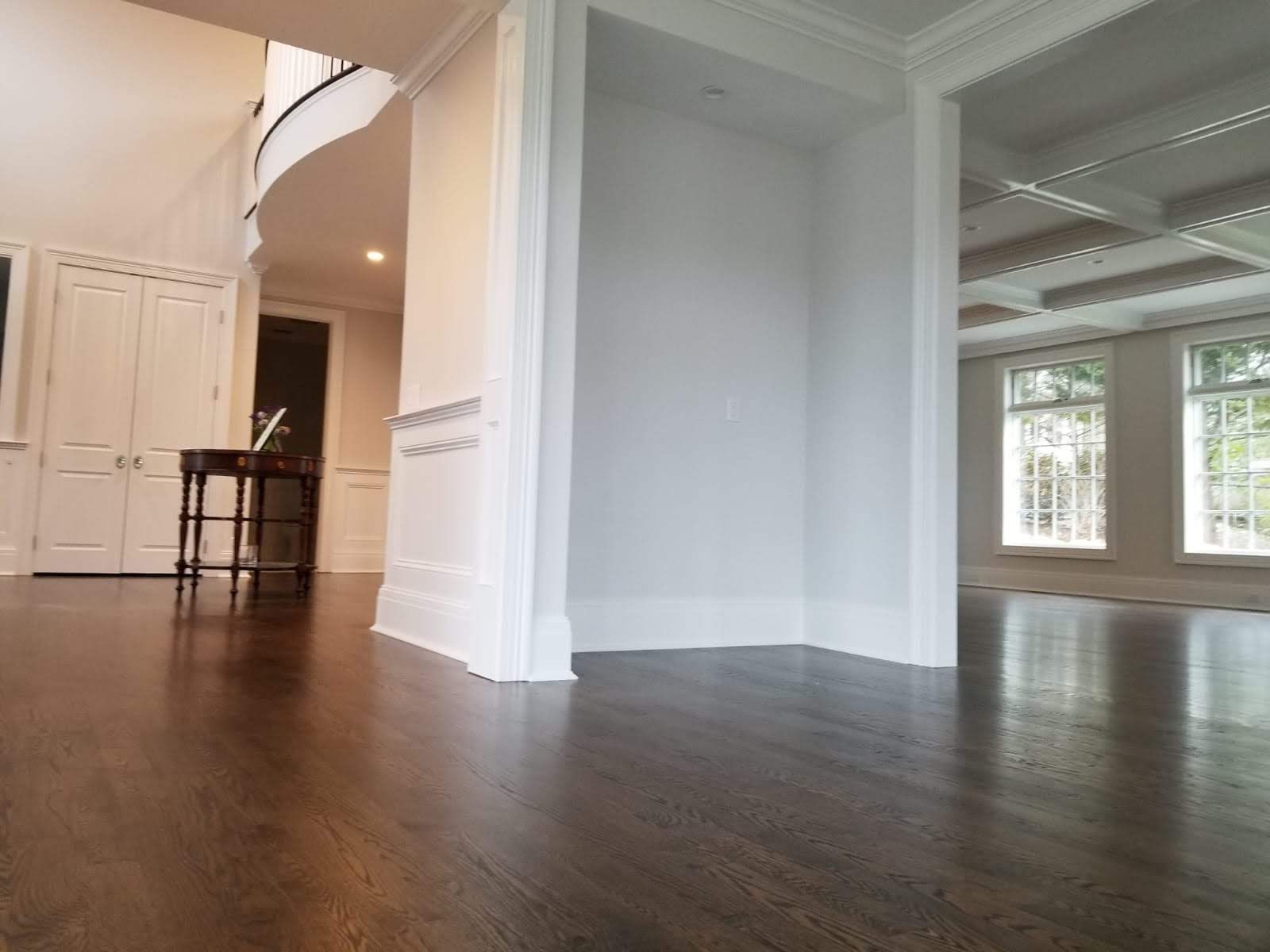 A large empty room with a wooden floor and white walls.