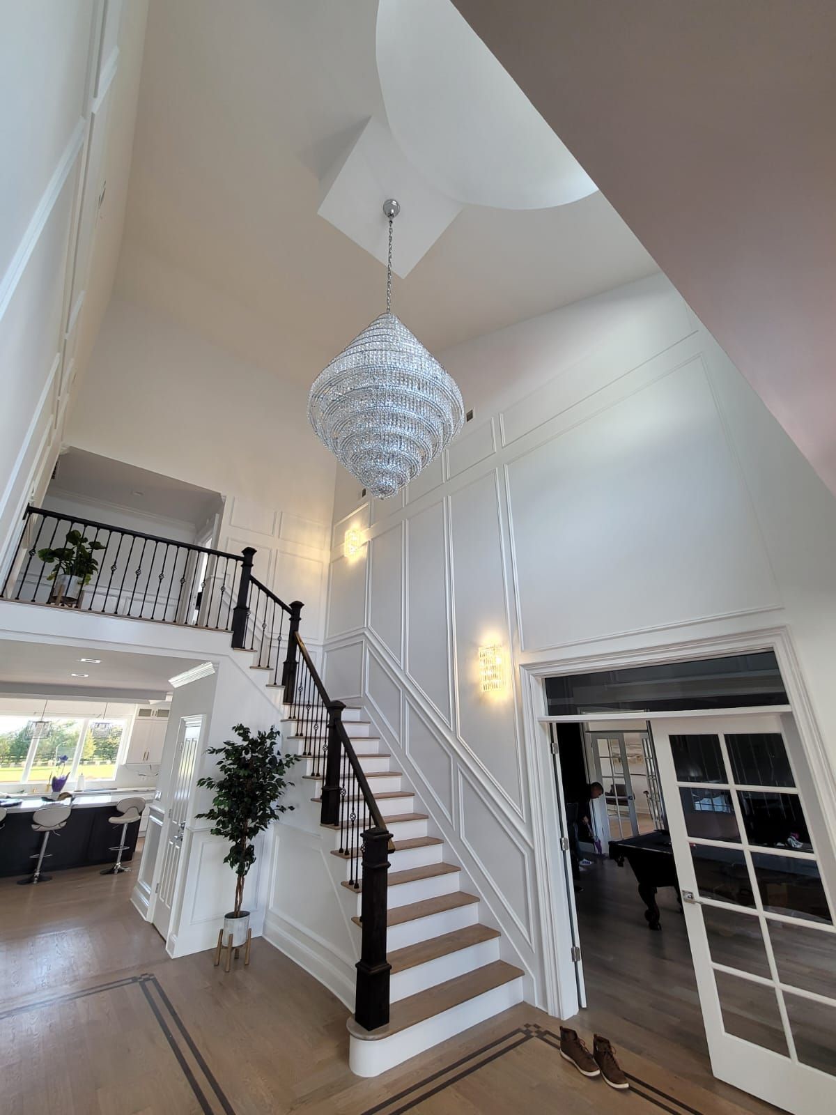 A large staircase in a house with a chandelier hanging from the ceiling.