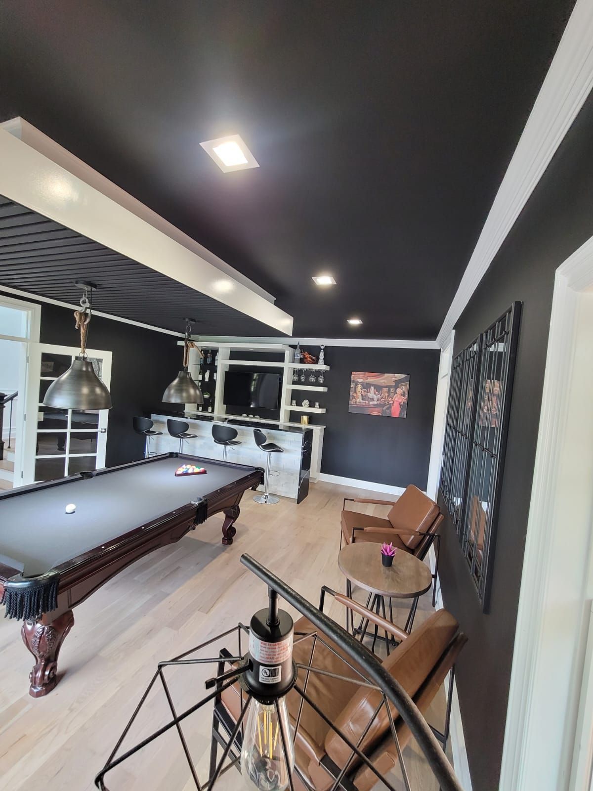 A room with a pool table and chairs in it