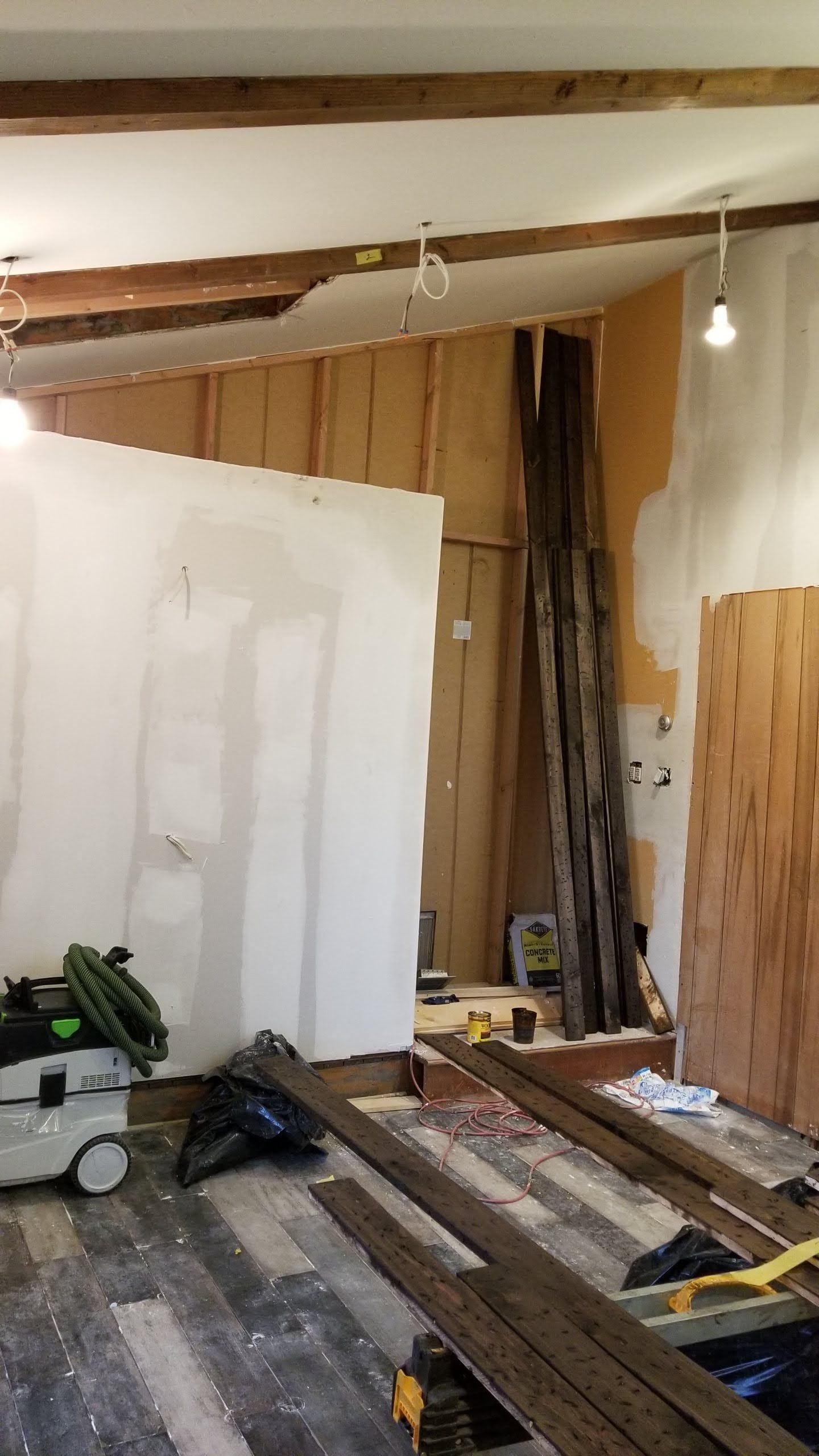 A room with a lot of wood and a vacuum cleaner in it.