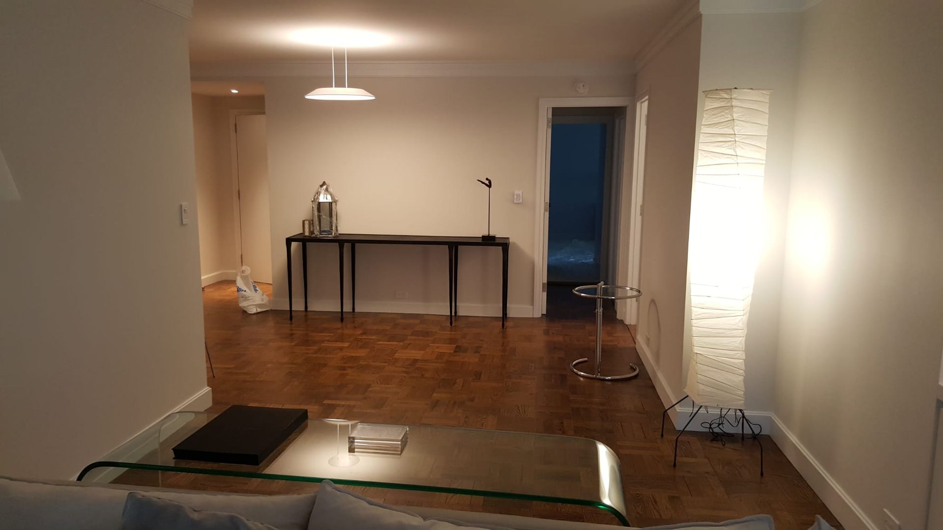 A living room with a couch, table and lamp.