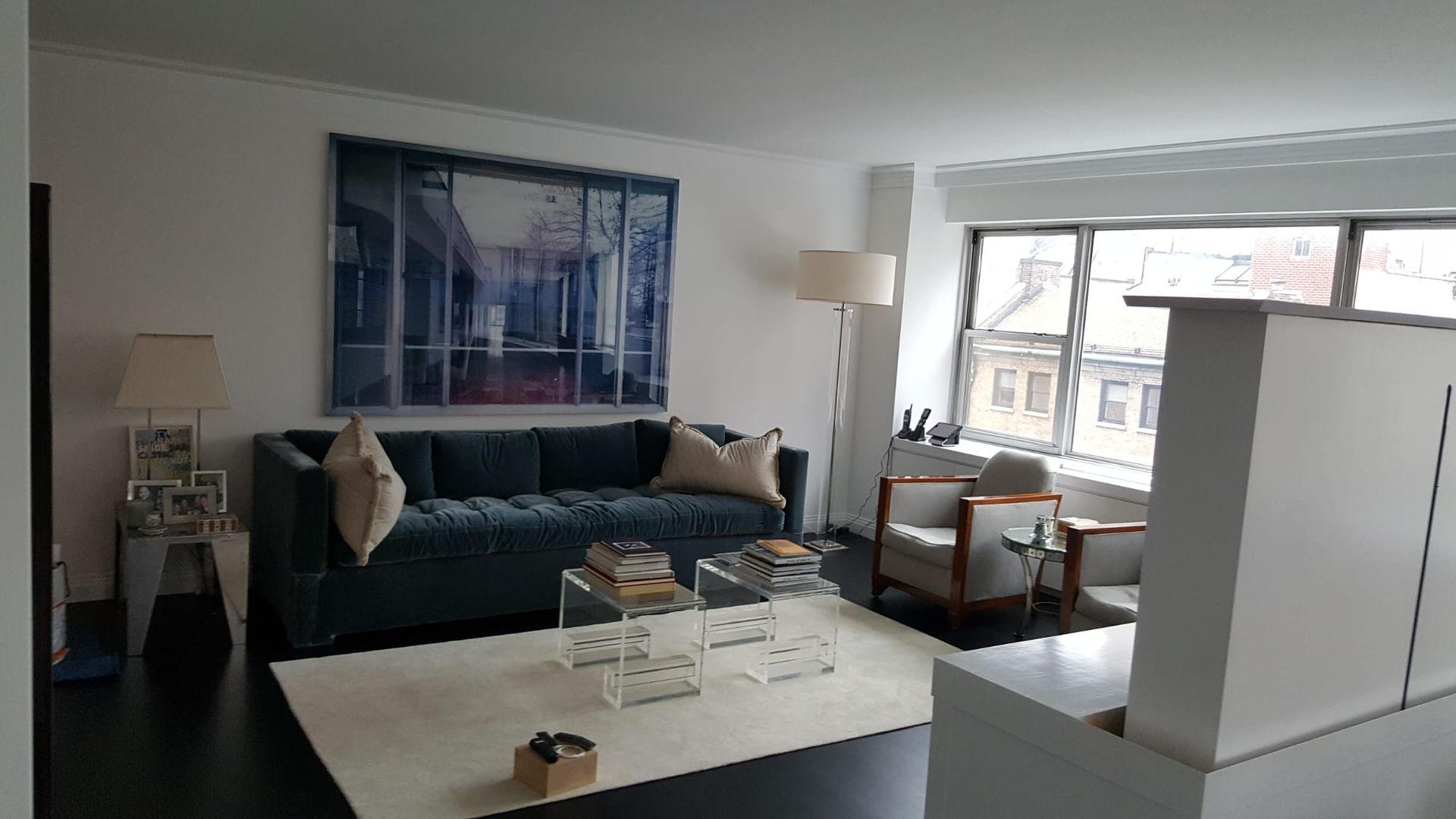 A living room with a blue couch and a white rug