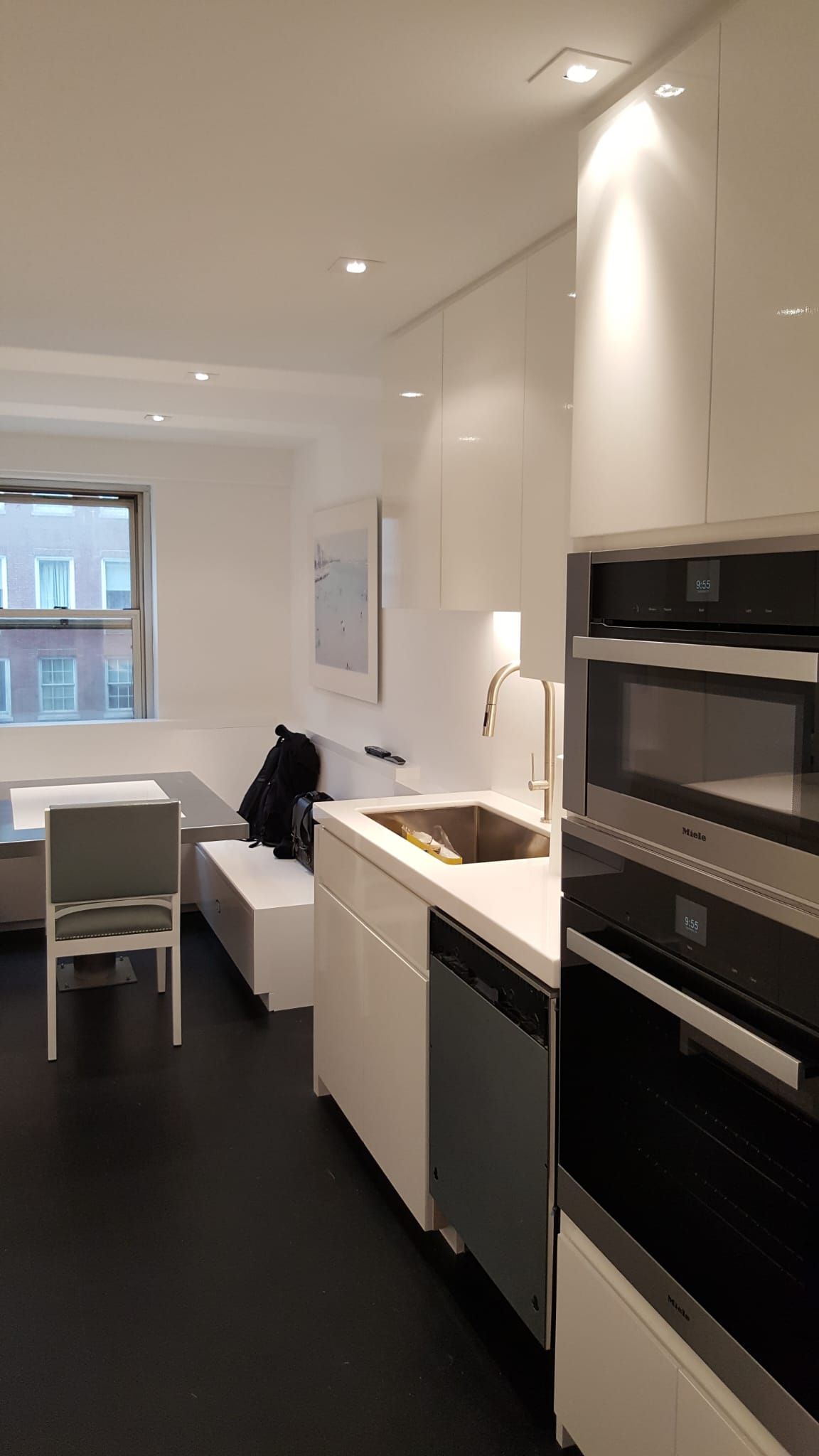 A kitchen with white cabinets, stainless steel appliances and a sink.