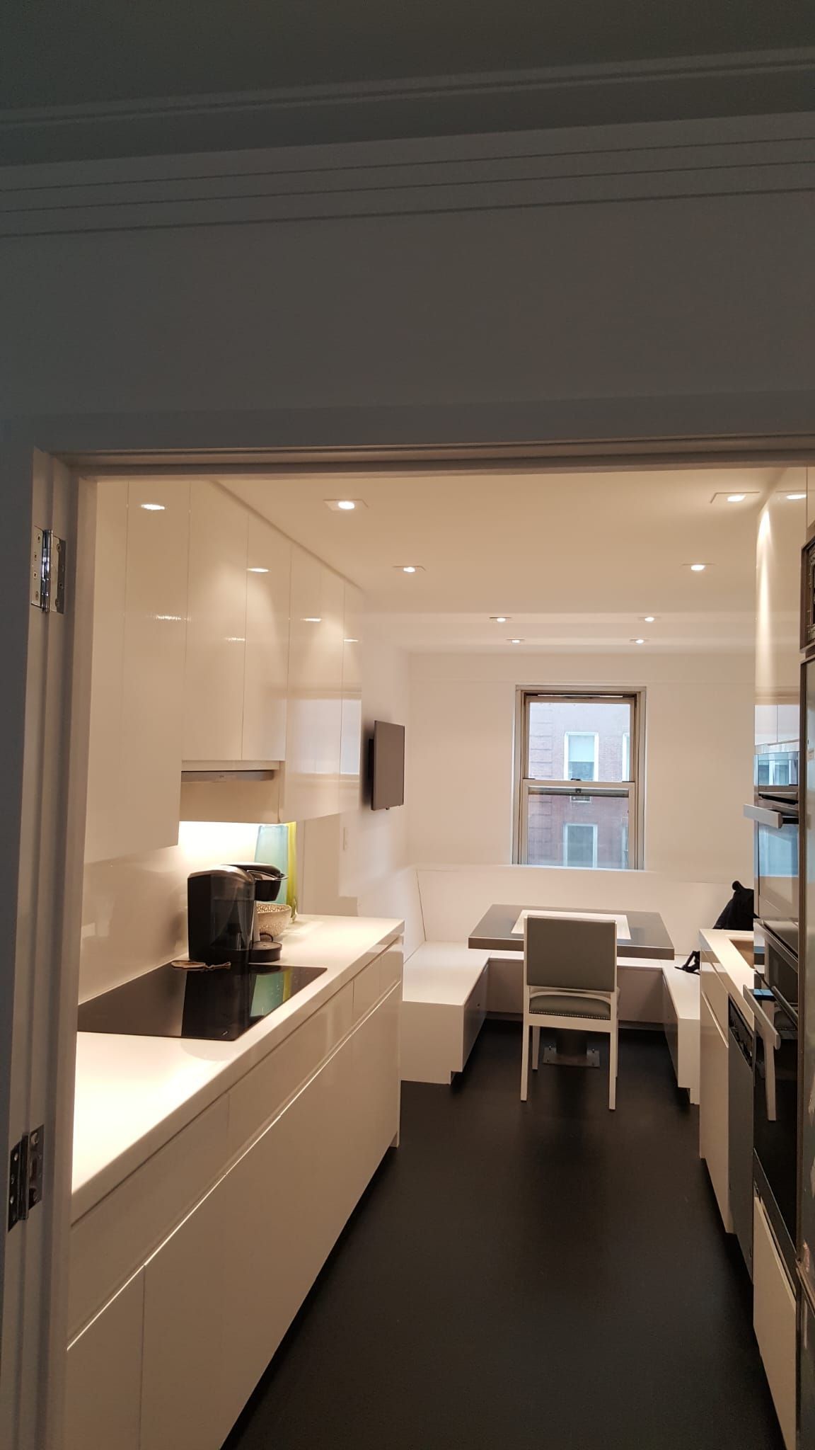 A kitchen with white cabinets and black floors