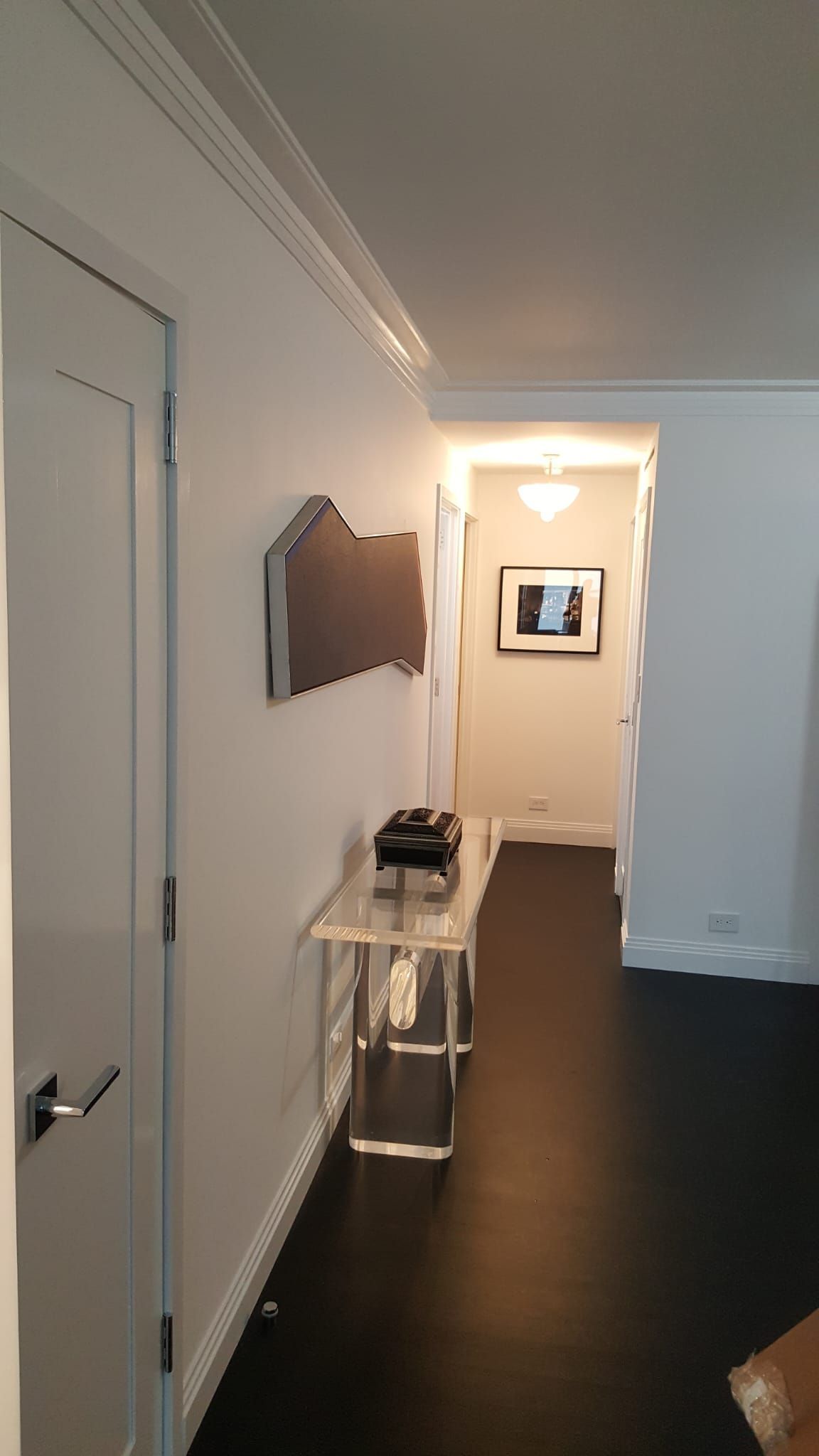 A hallway with a table and a picture on the wall