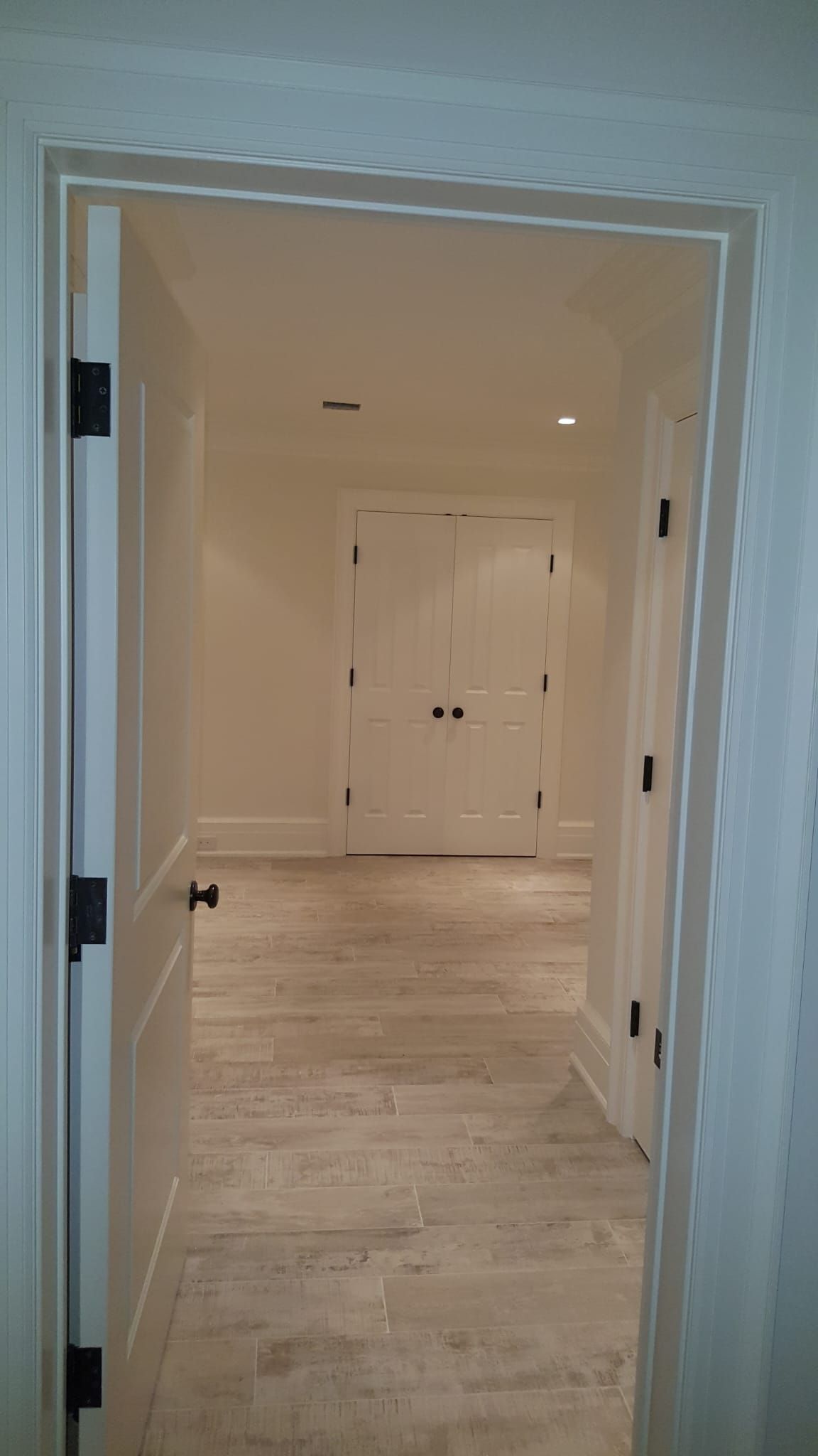 A hallway with a door open leading to a doorway.