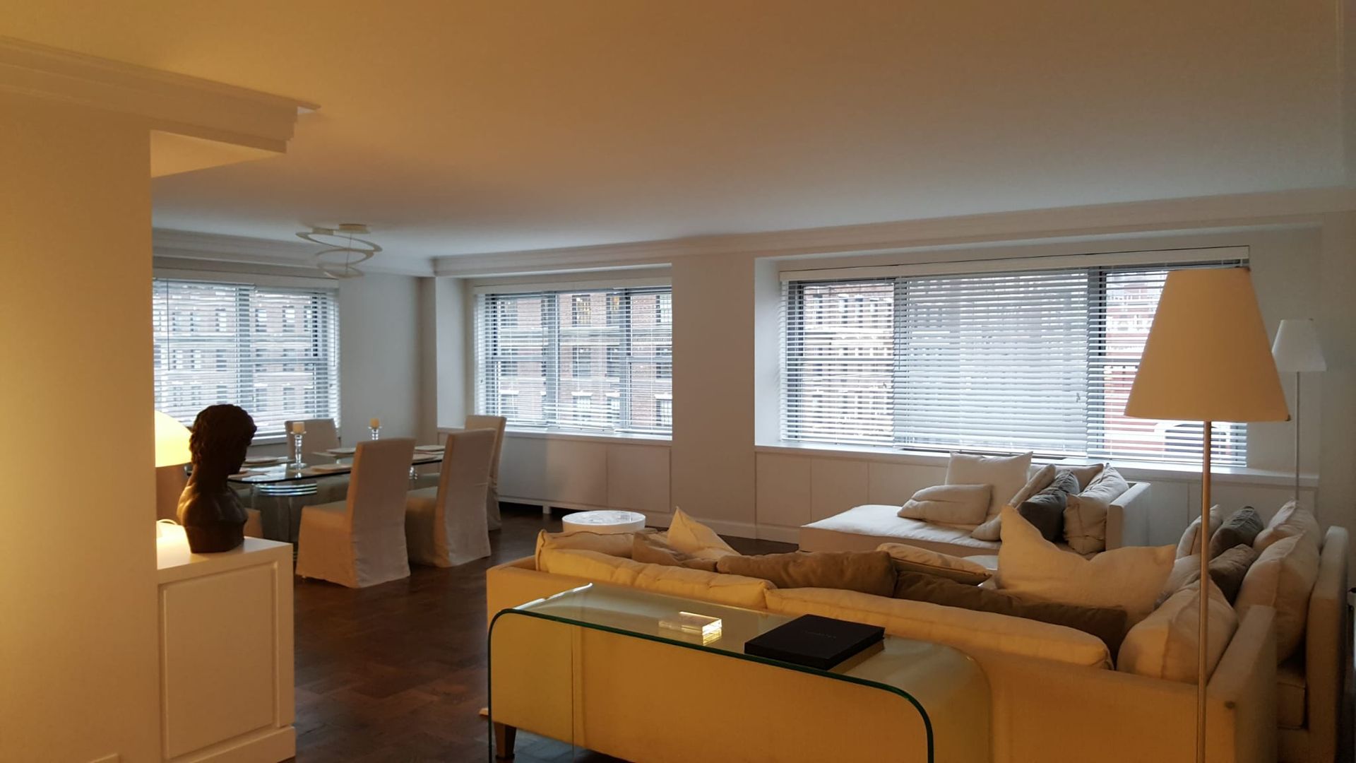 A living room with a couch, table, chairs and a lamp.