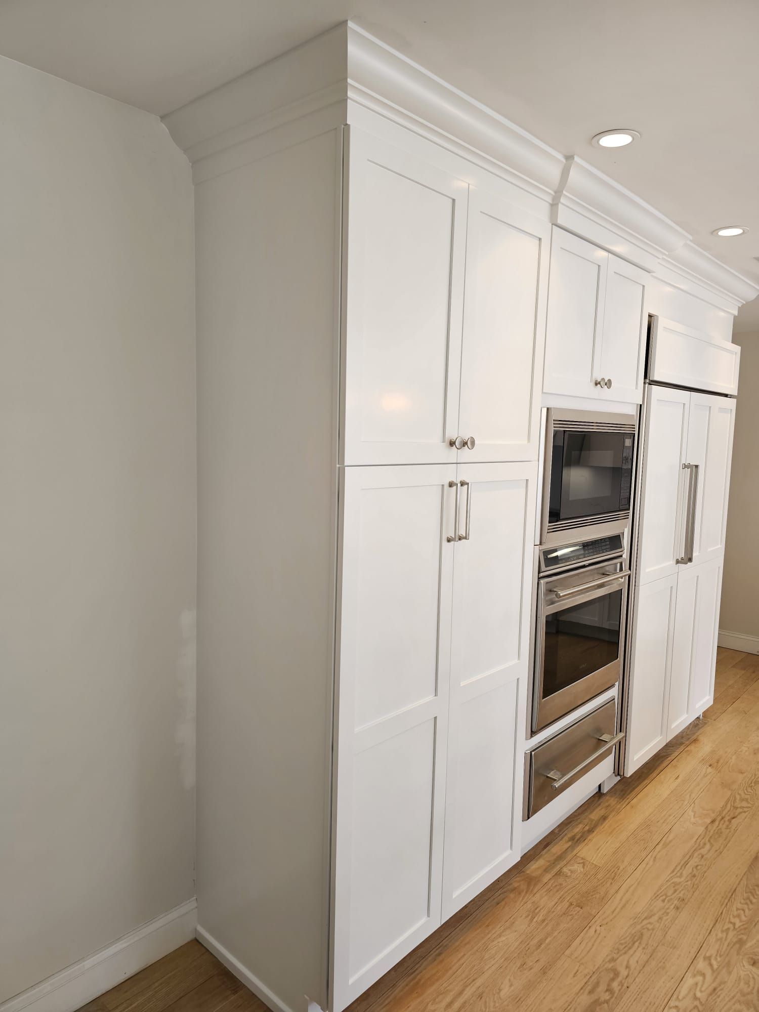 A kitchen with white cabinets and stainless steel appliances