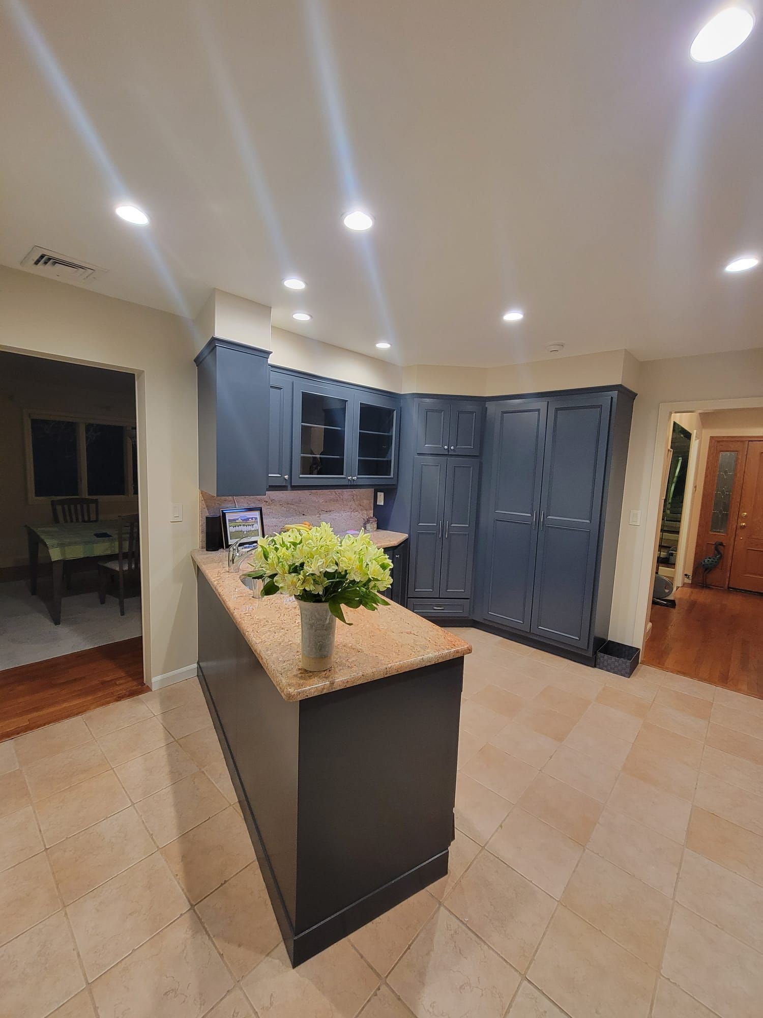 A kitchen with a large island and a vase of flowers on the counter.