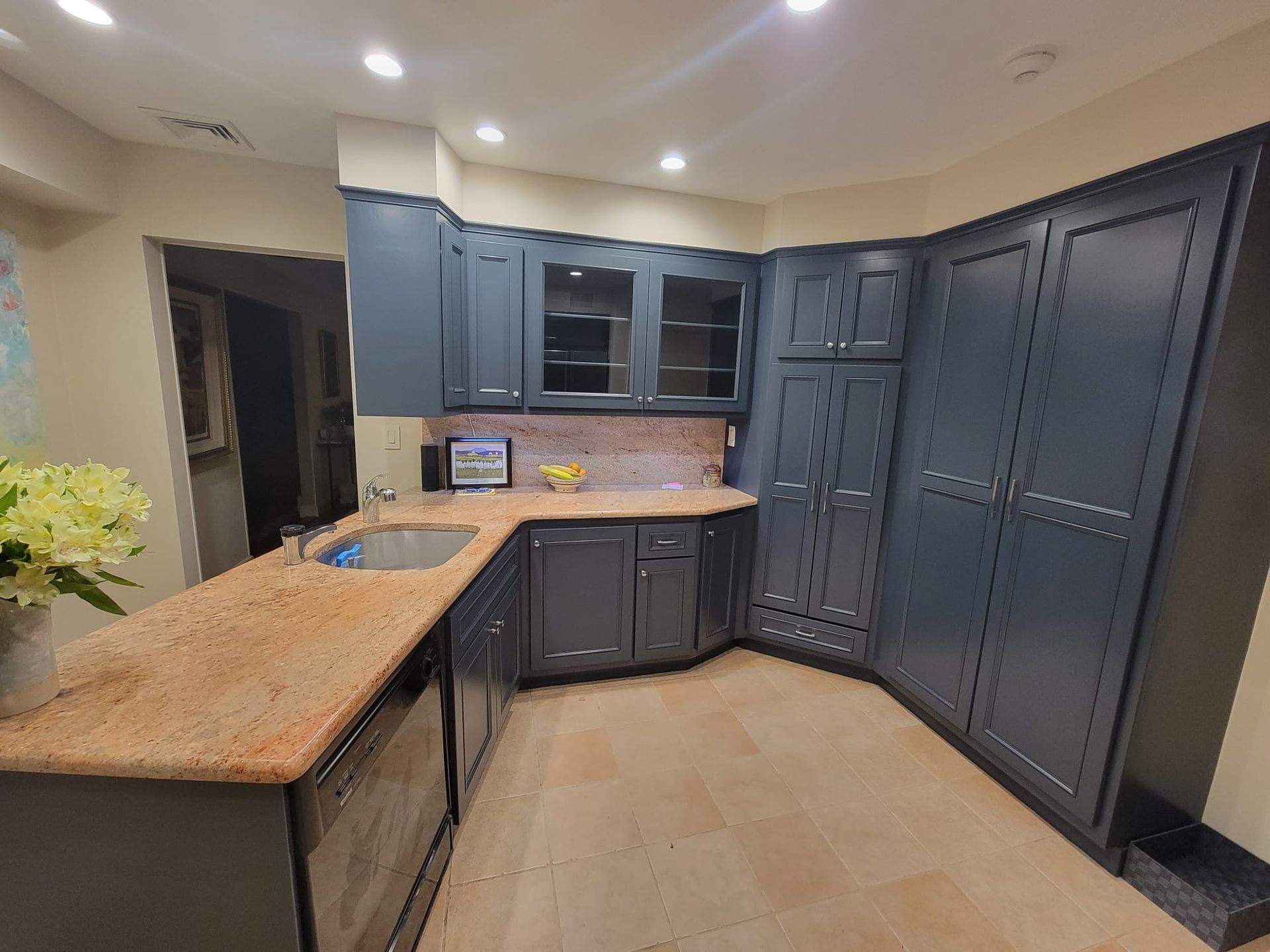 A kitchen with a sink, cabinets, and granite counter tops.