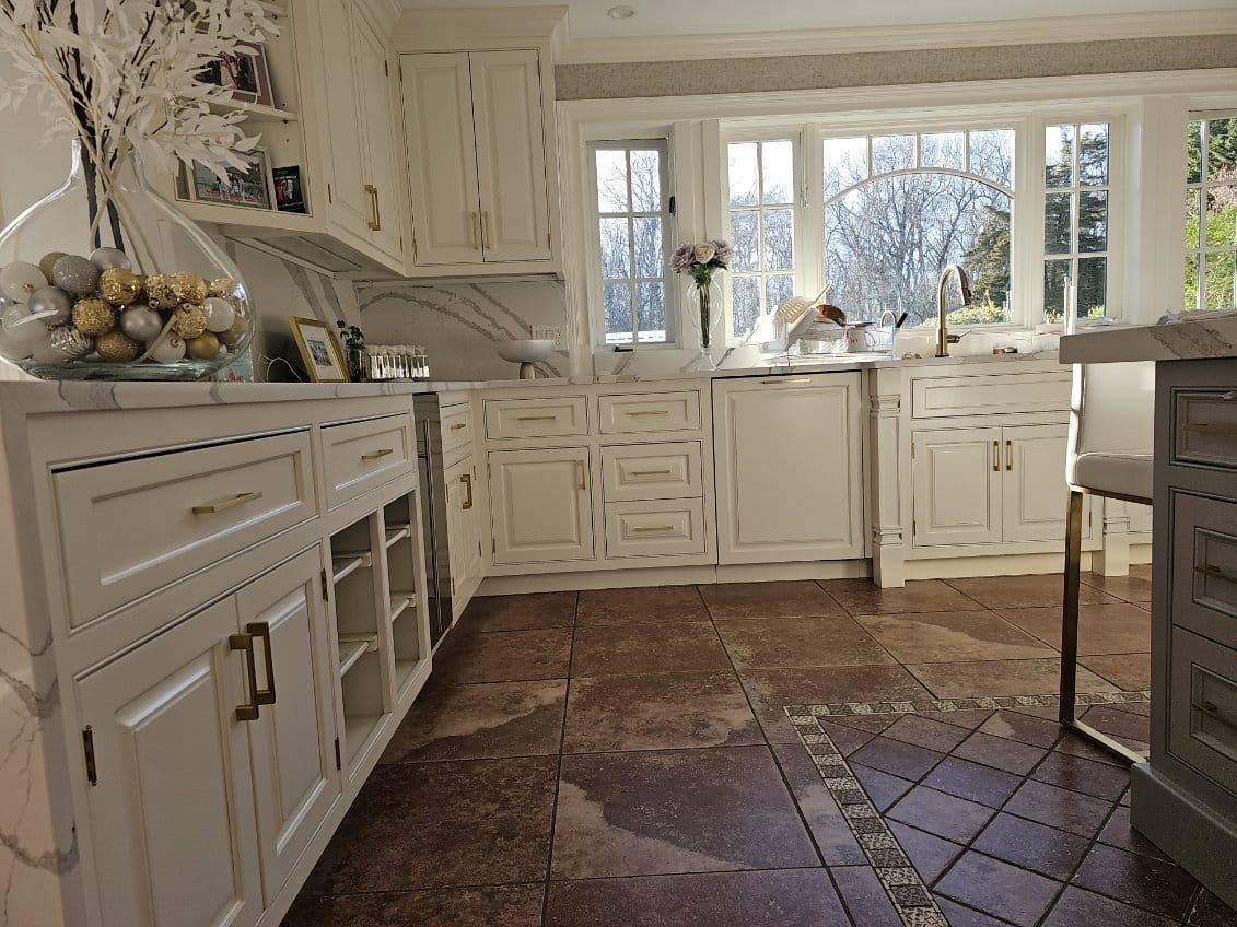 A kitchen with white cabinets and a tile floor.