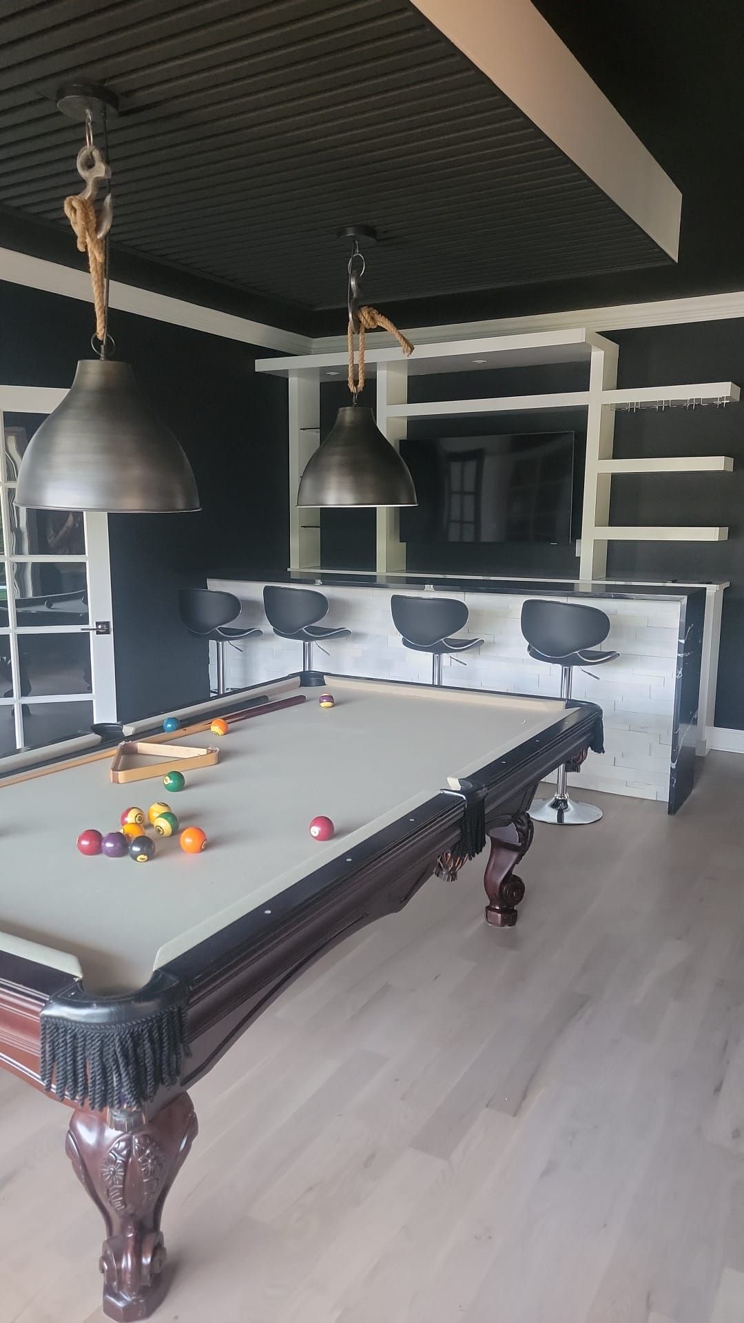 There is a pool table in the middle of the room.