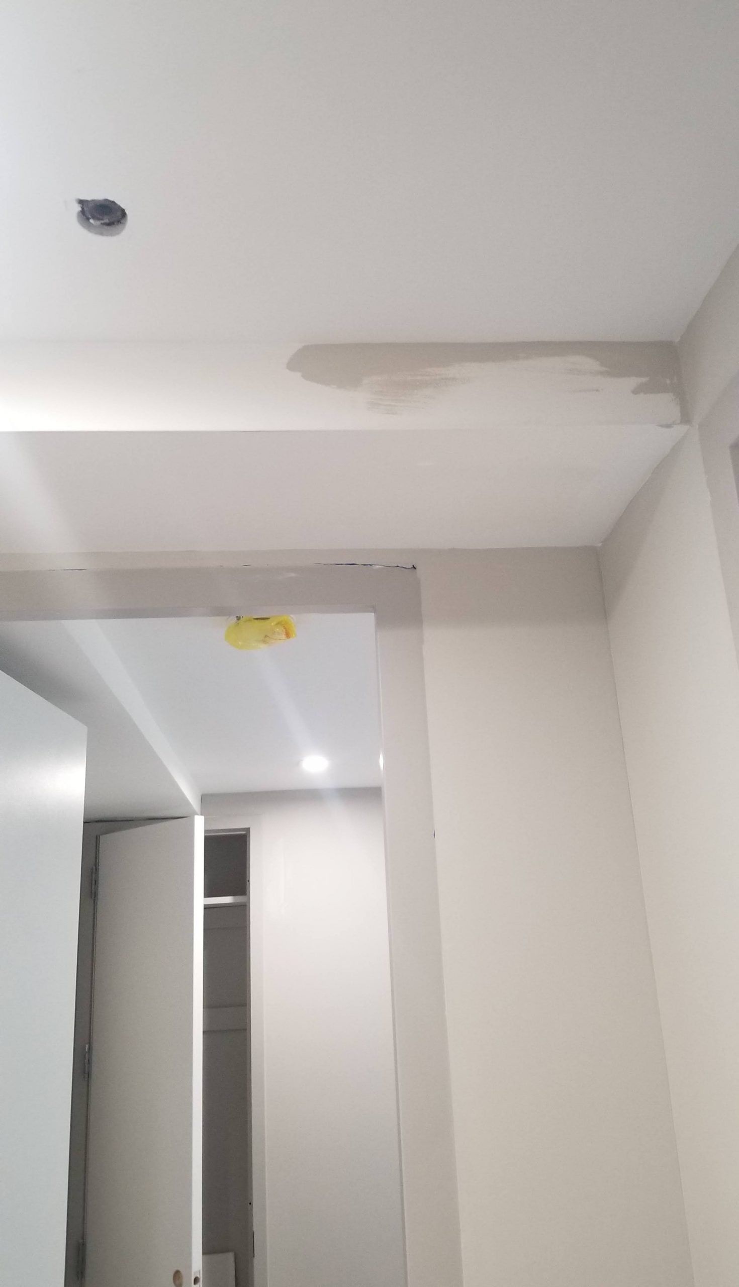 A room with a ceiling that is missing a piece of paint.