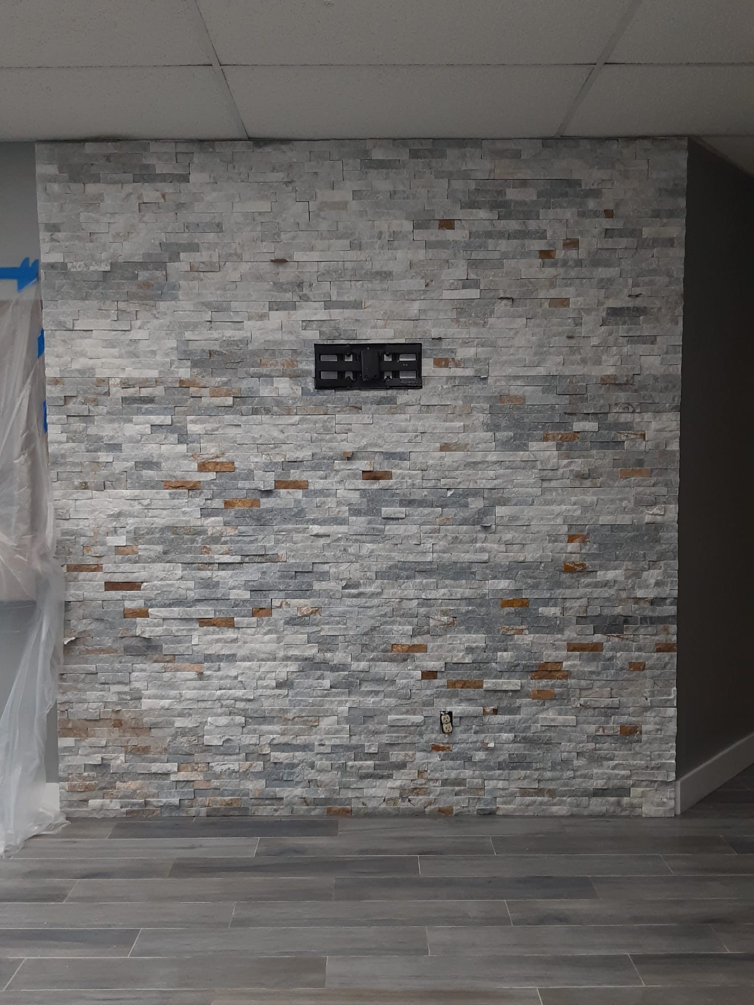 A room with a stone wall and a wooden floor.