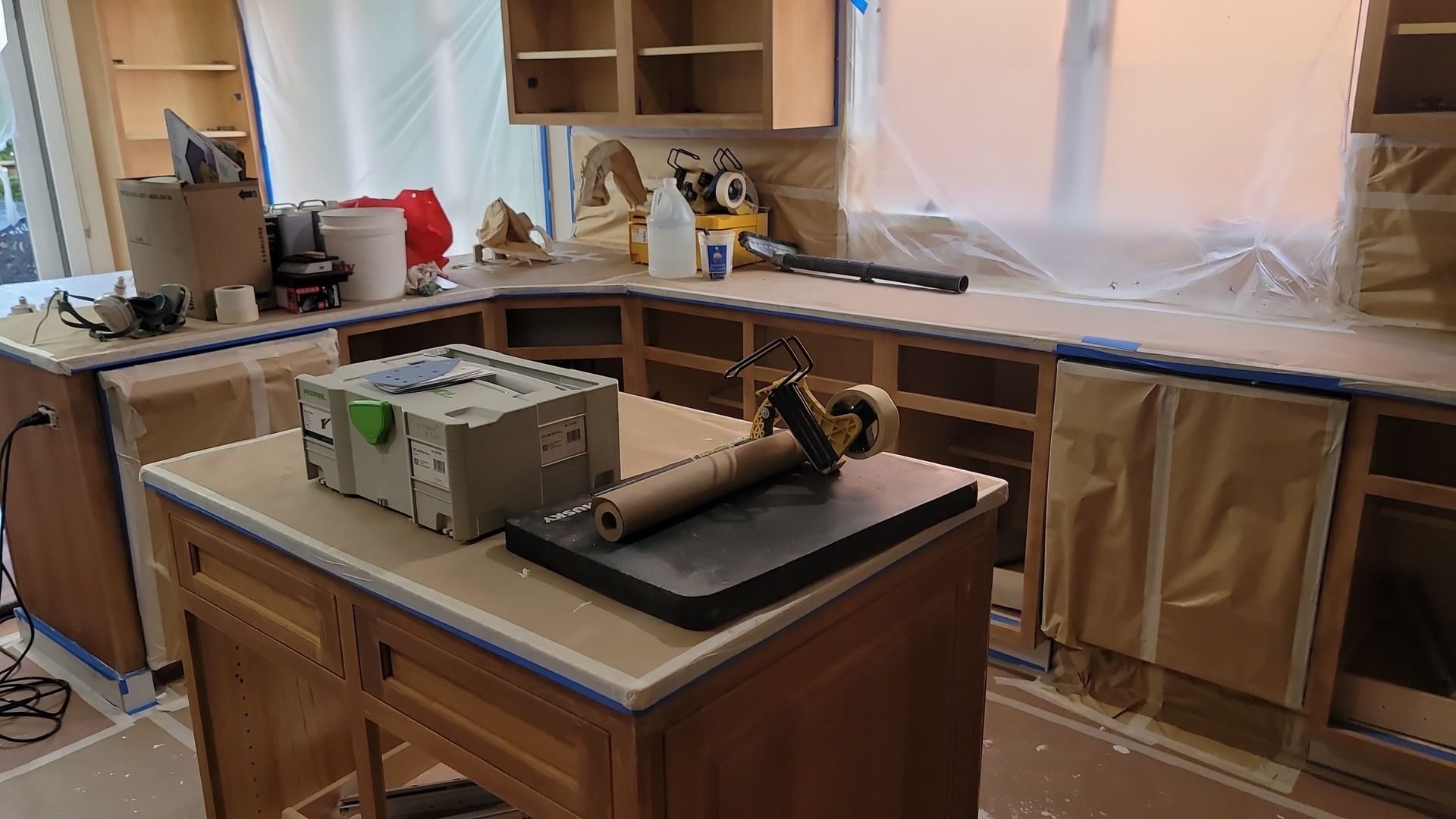 A kitchen under construction with a large island in the middle.