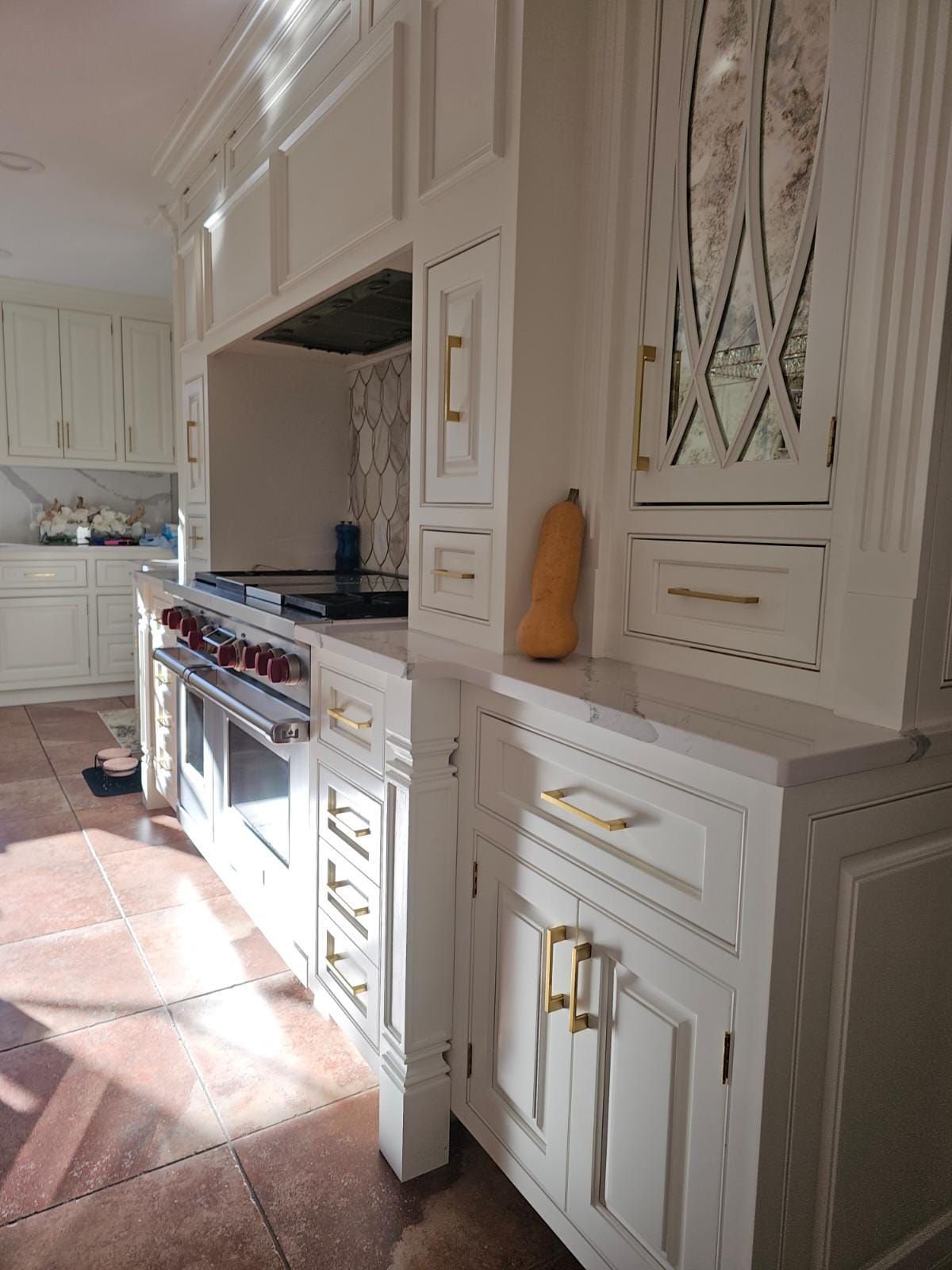 A kitchen with white cabinets and a stove top oven.