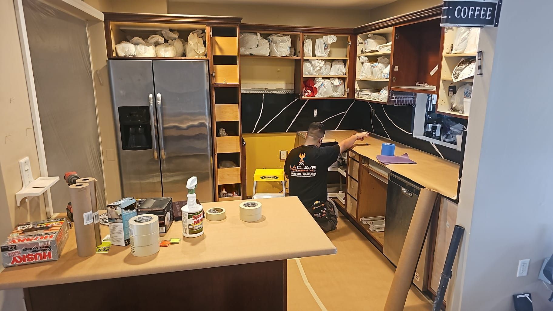 A man is sitting at a counter in a kitchen.