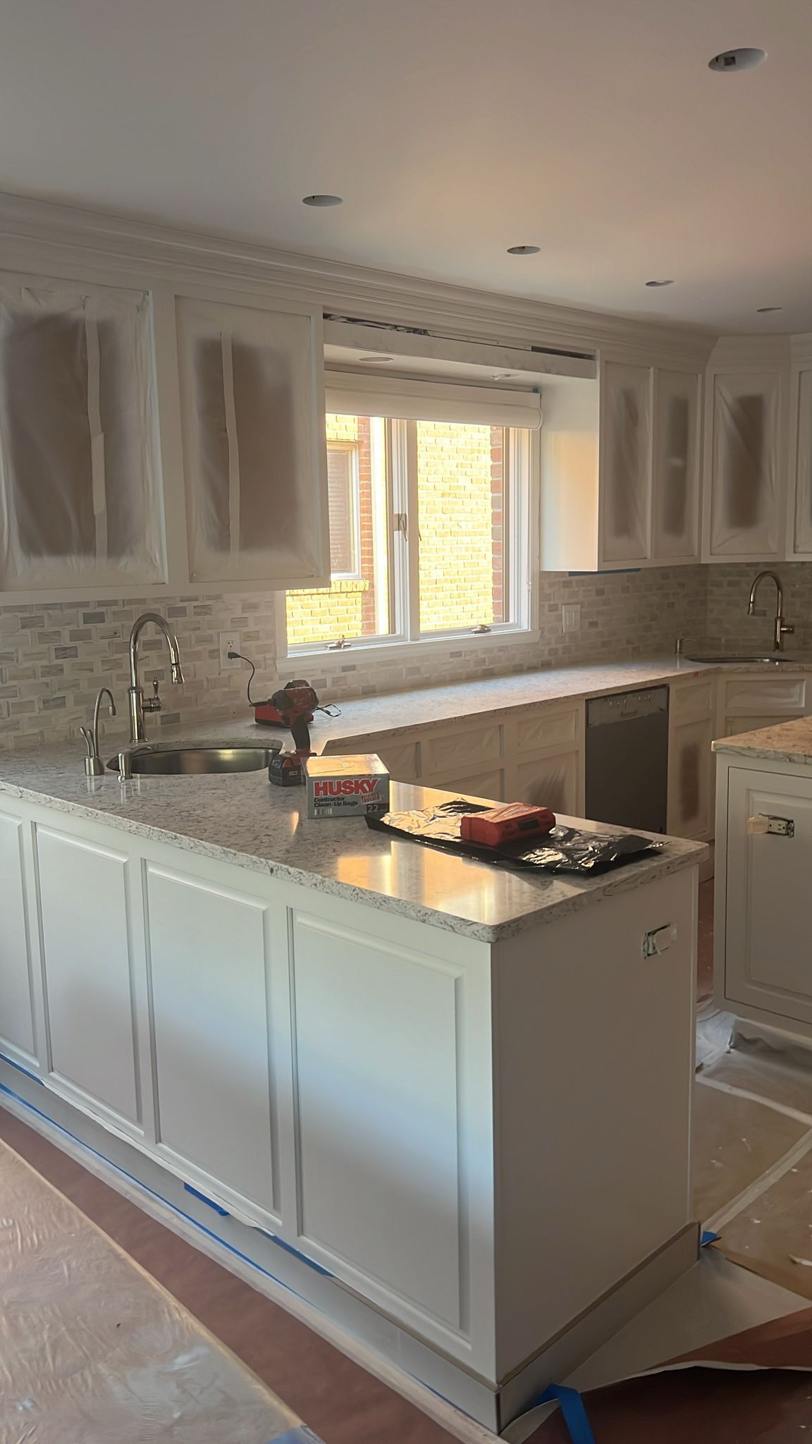 A kitchen with white cabinets and granite counter tops is being remodeled.