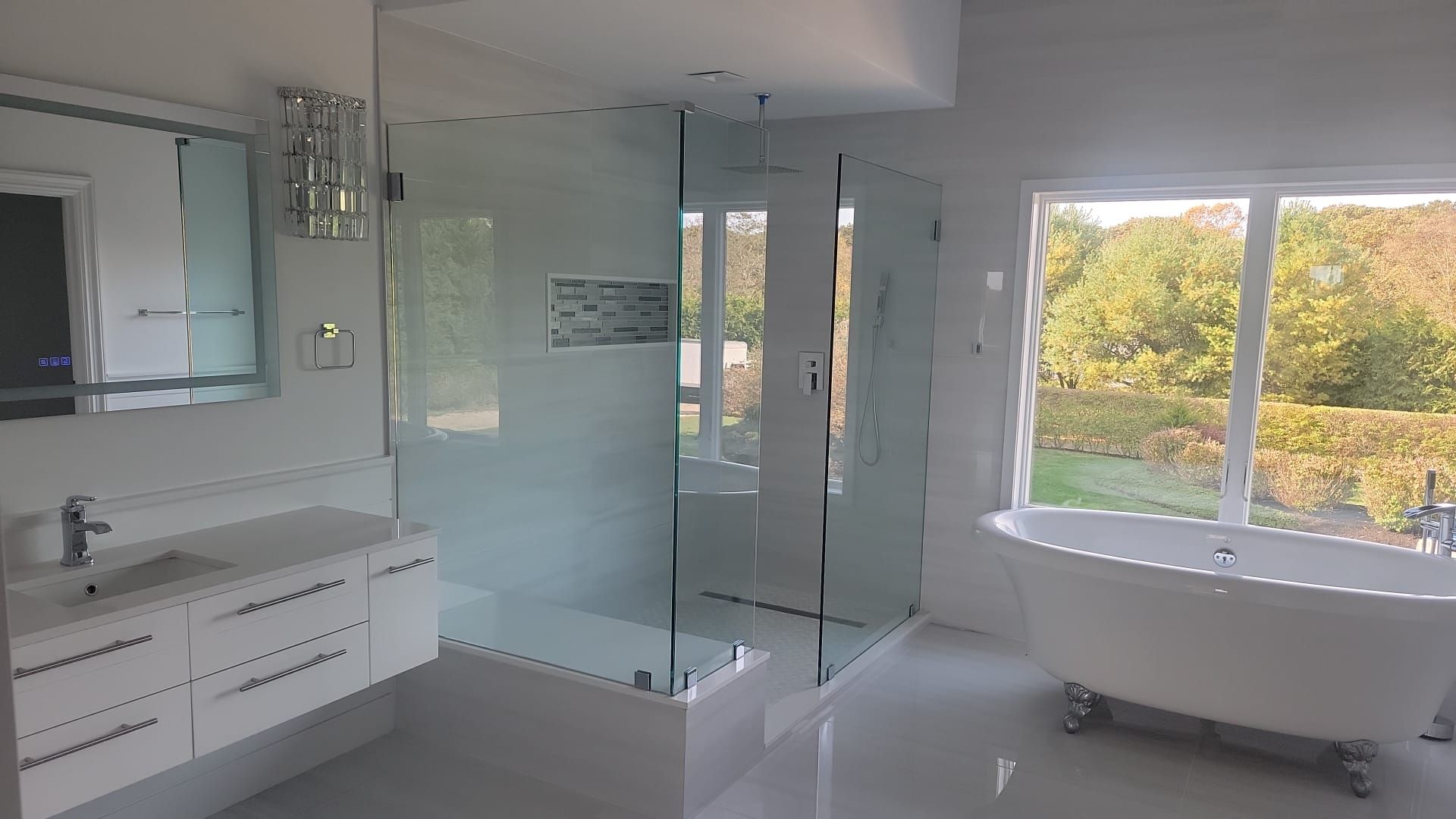 A bathroom with a tub, sink, shower and window.