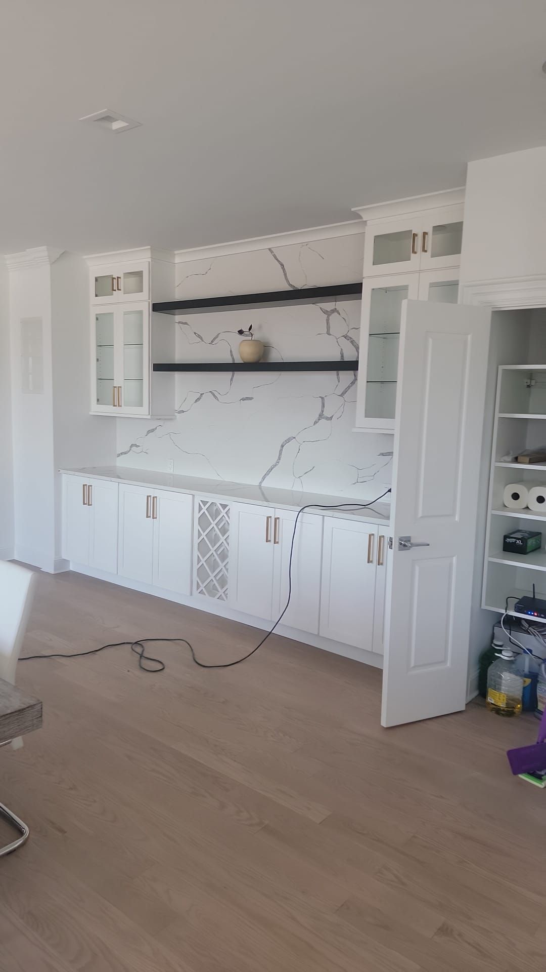 A kitchen with white cabinets and marble counter tops is being remodeled.