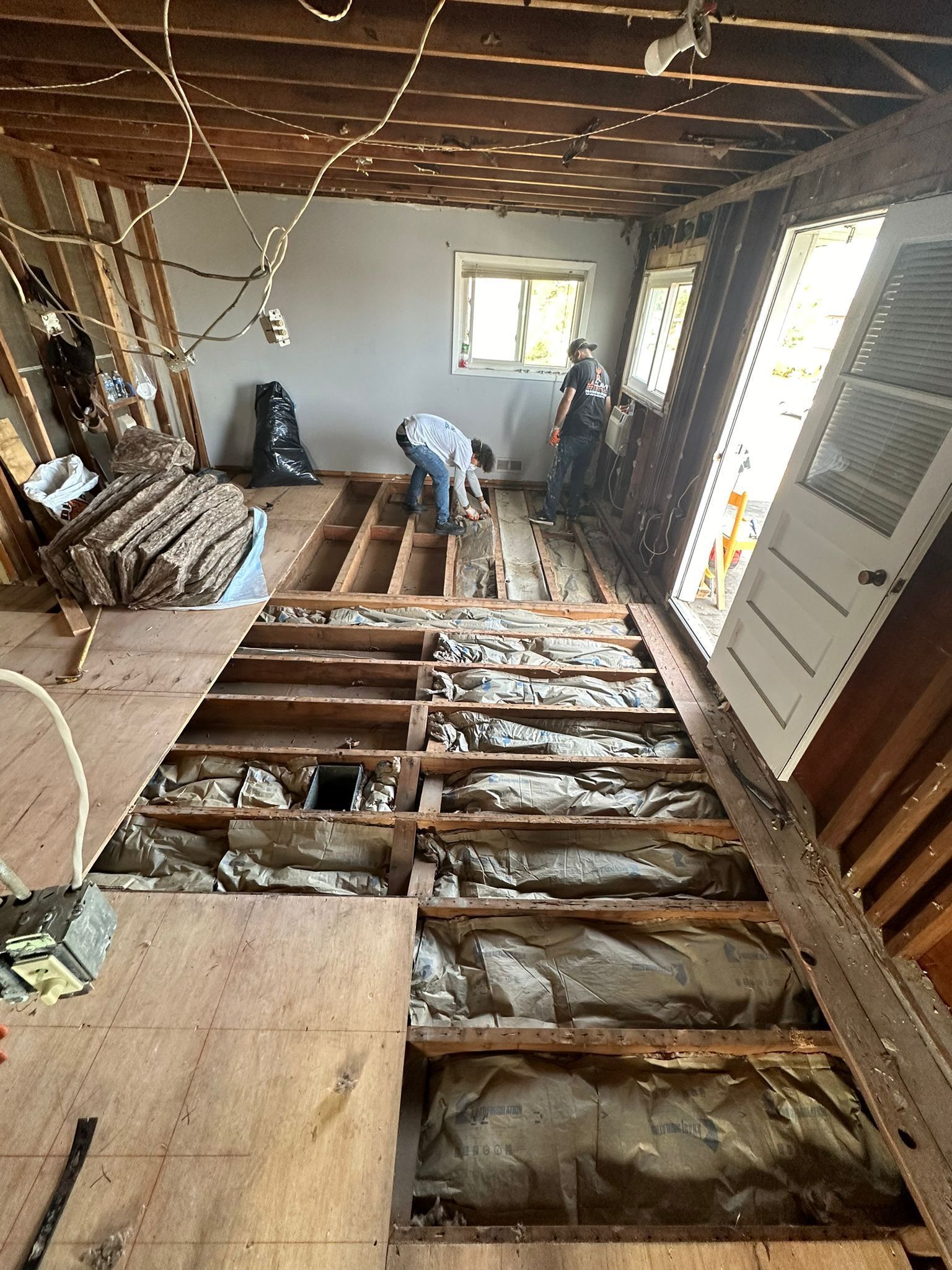 A man is working on the floor of a house.