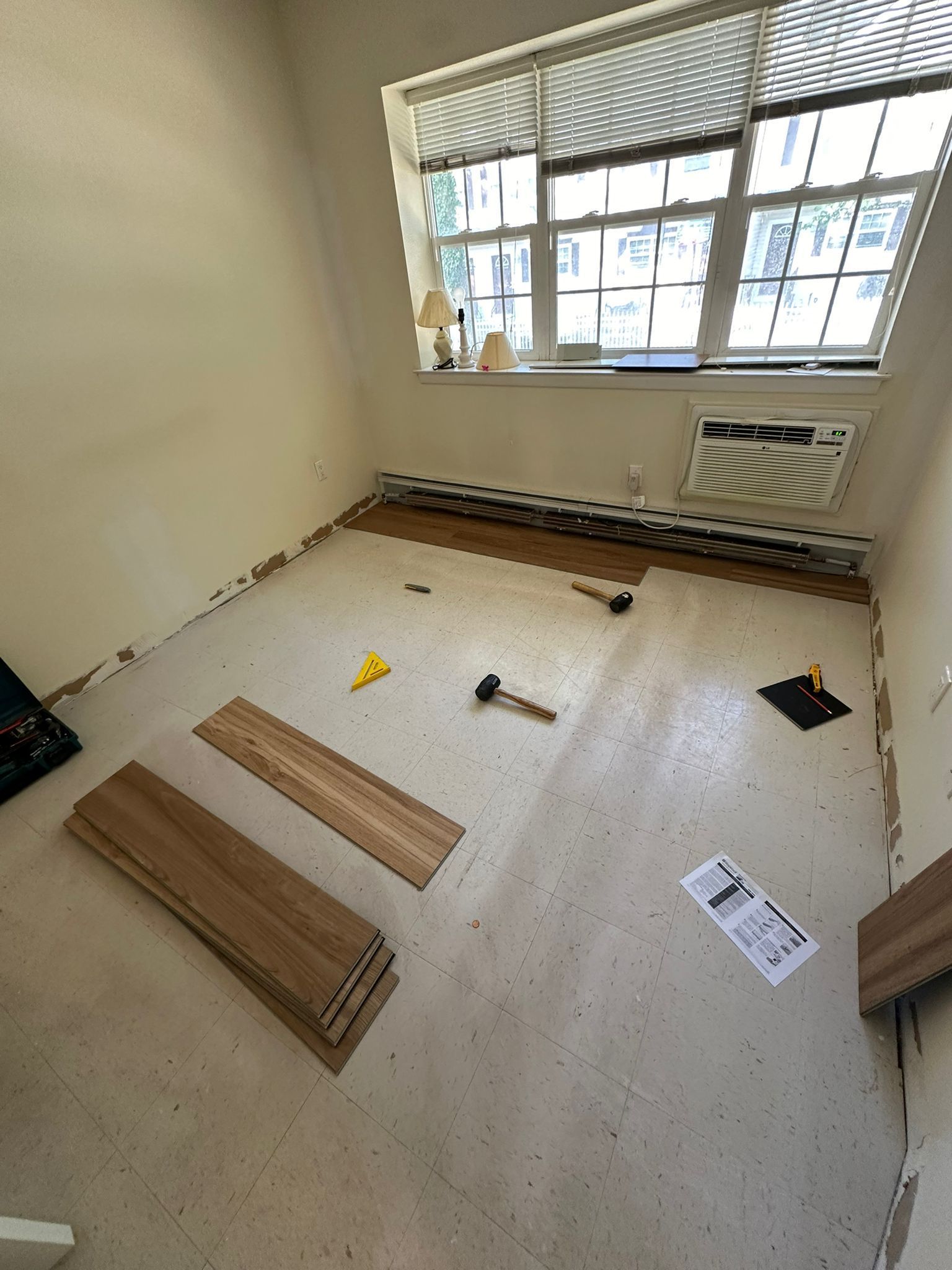 A room with a lot of wooden boards on the floor and a window.