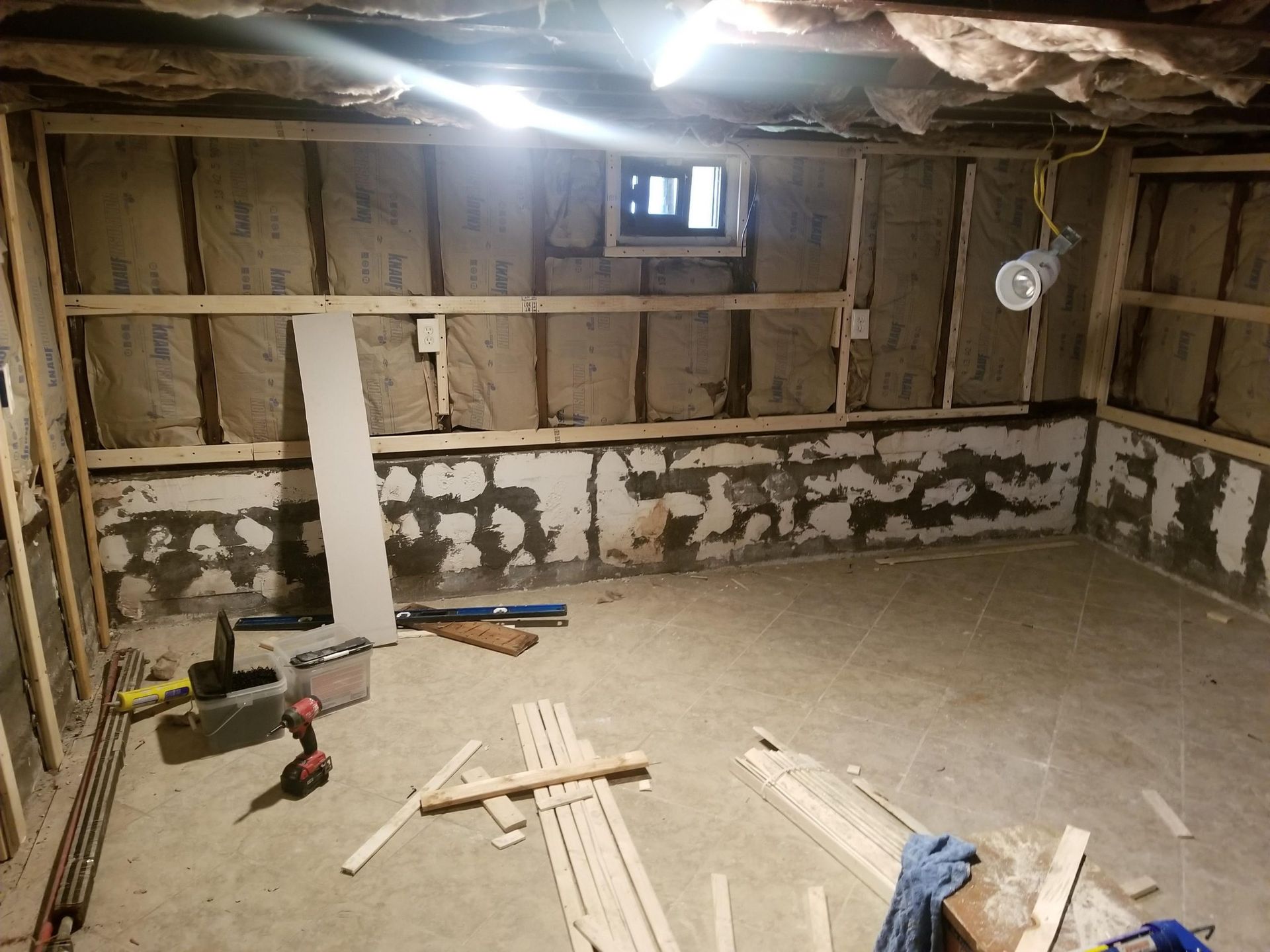 A room with a lot of wood and tools on the floor.