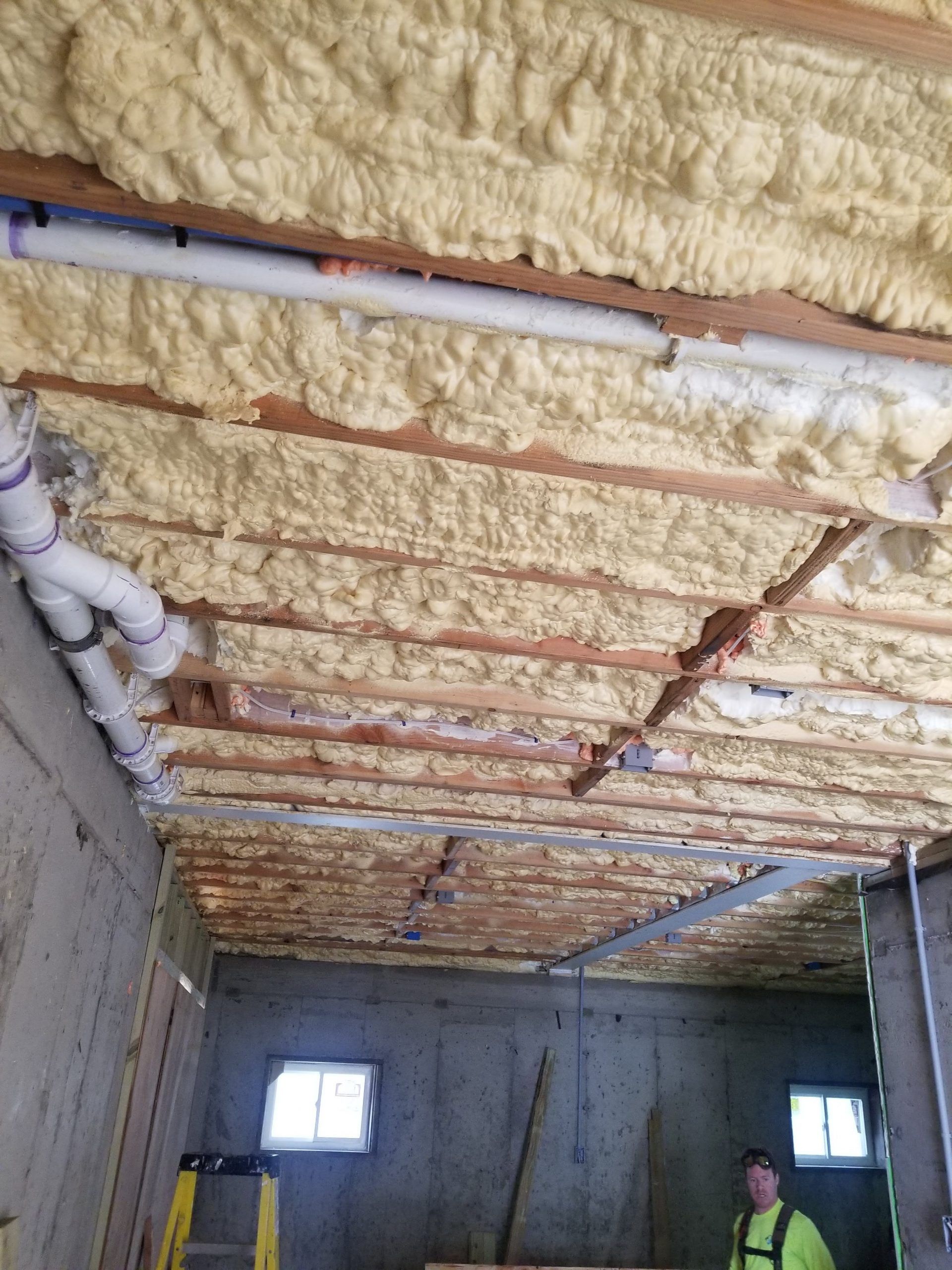 A man is standing in a room with foam on the ceiling.