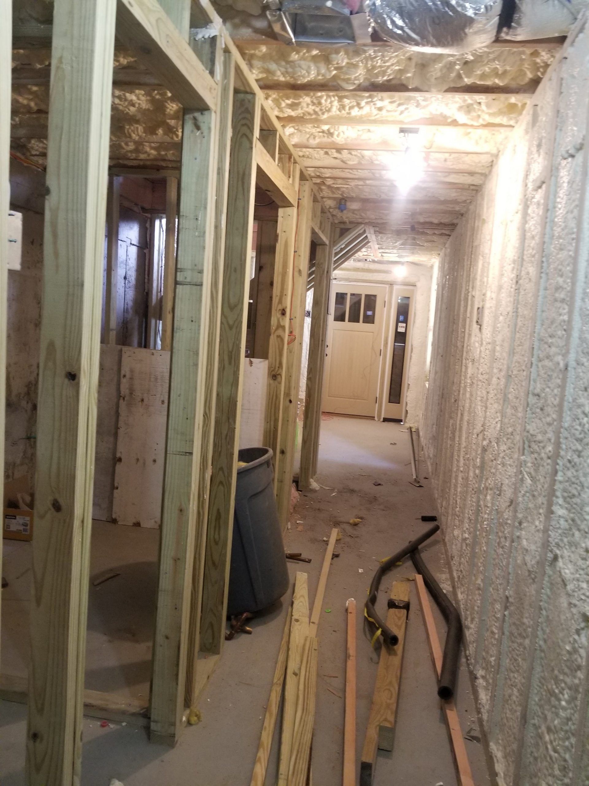 A hallway in a house under construction with wooden frames