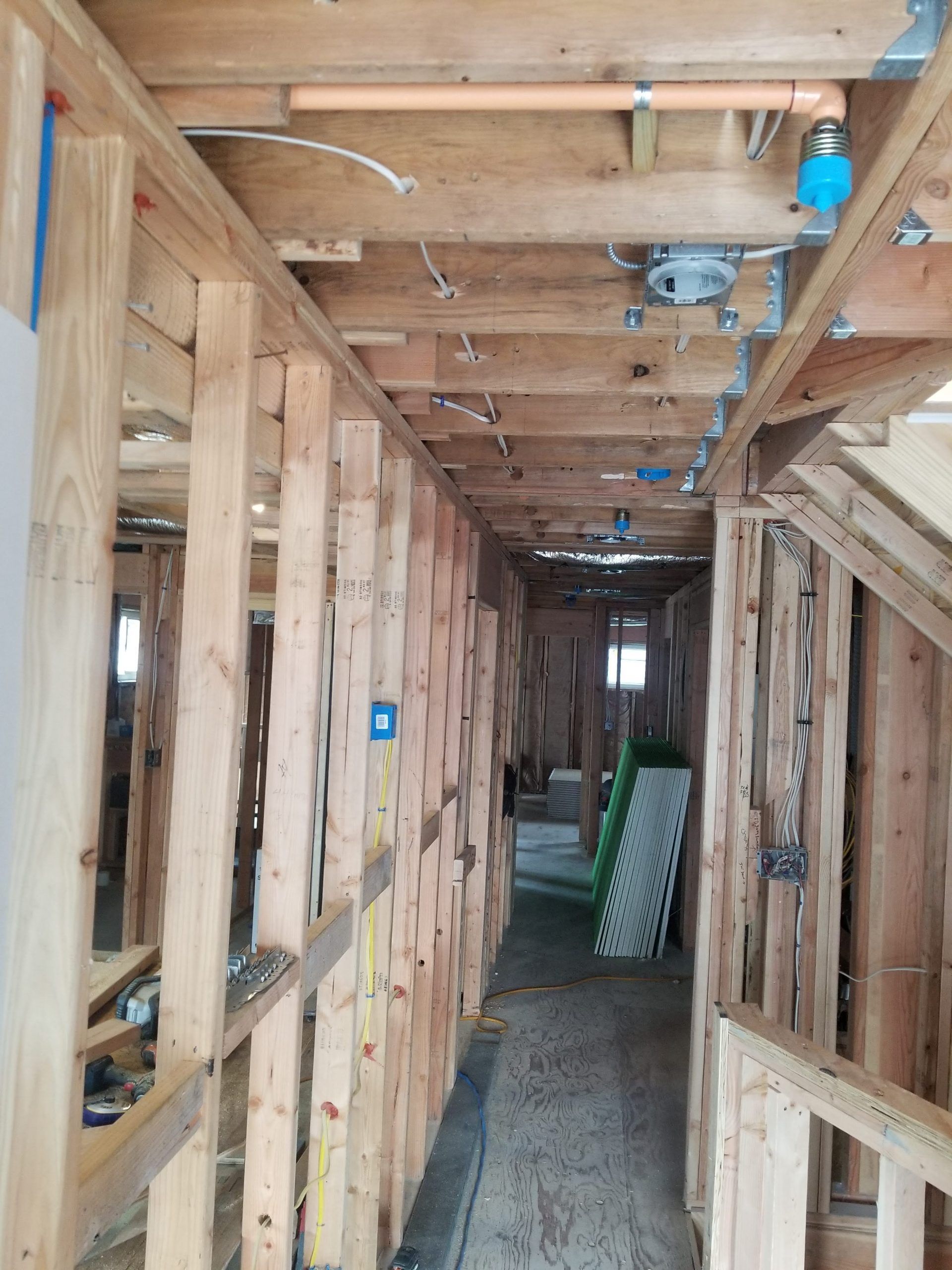 A hallway in a house under construction with wooden beams