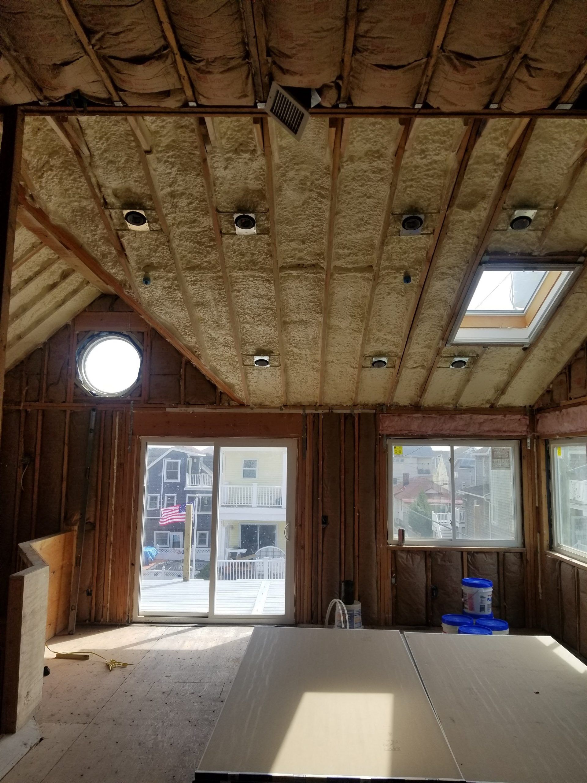 A room with a lot of insulation on the ceiling and a skylight.