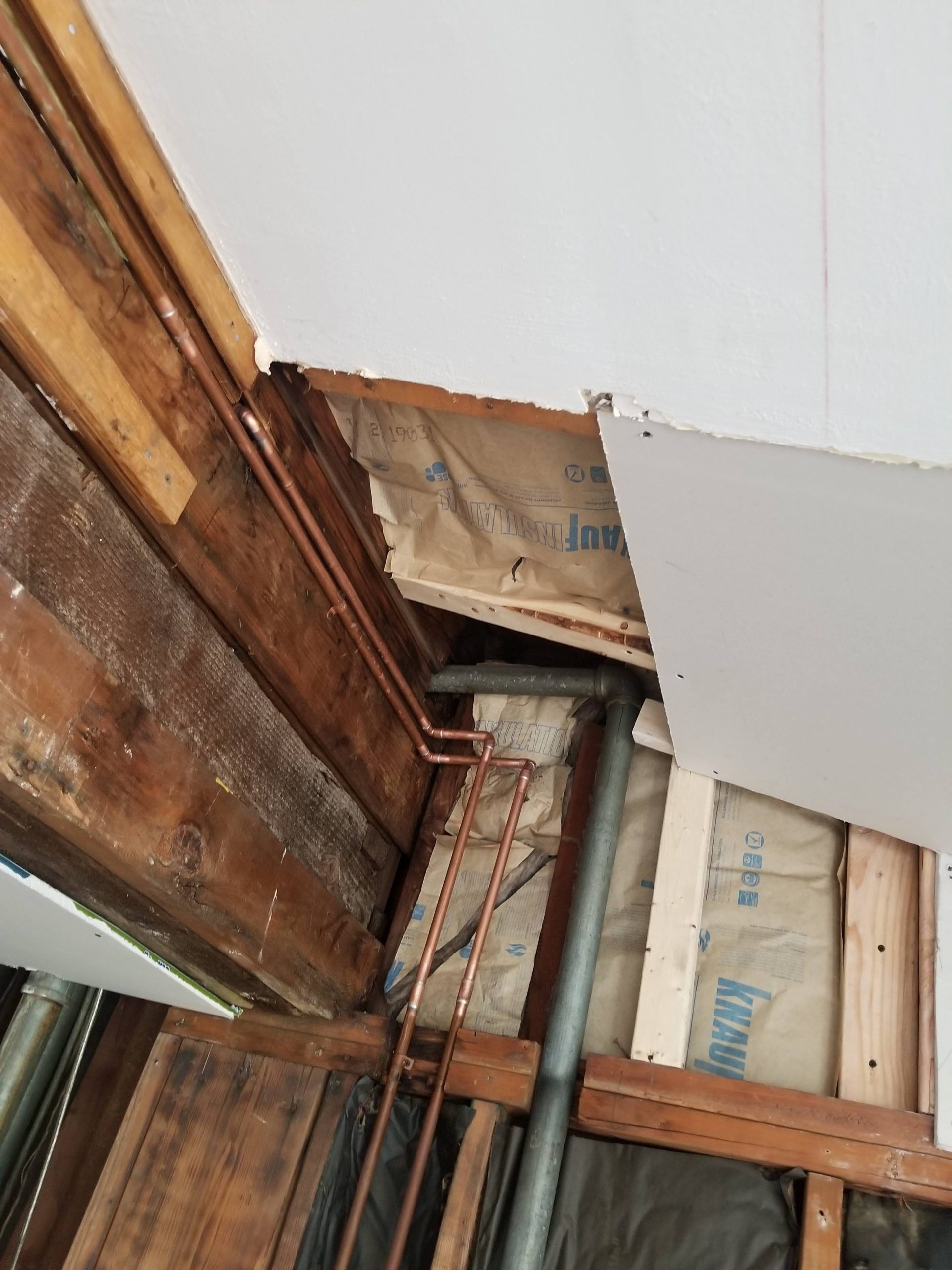 A ceiling with a hole in it and a pipe coming out of it.