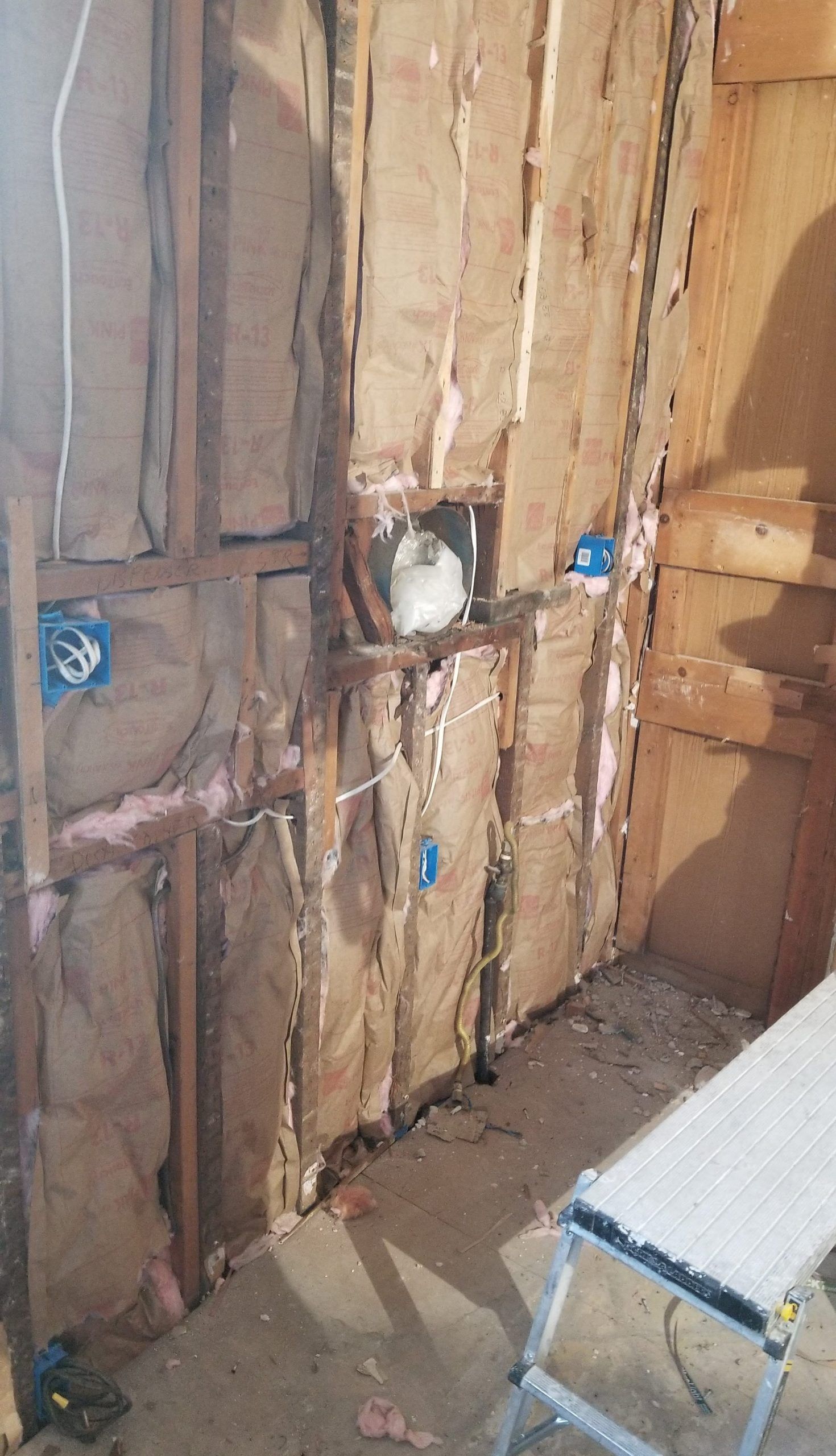 A room with a wooden wall and a ladder in it.