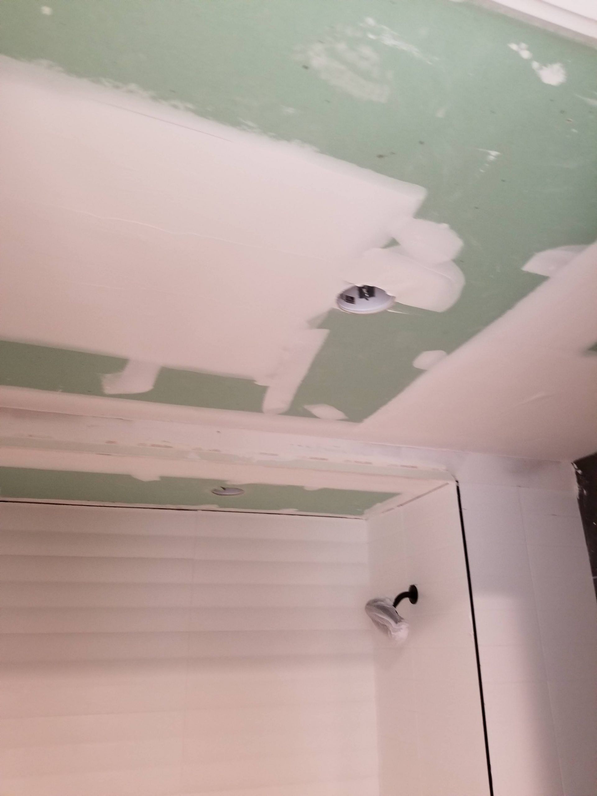 A ceiling with a hole in it and a shower head