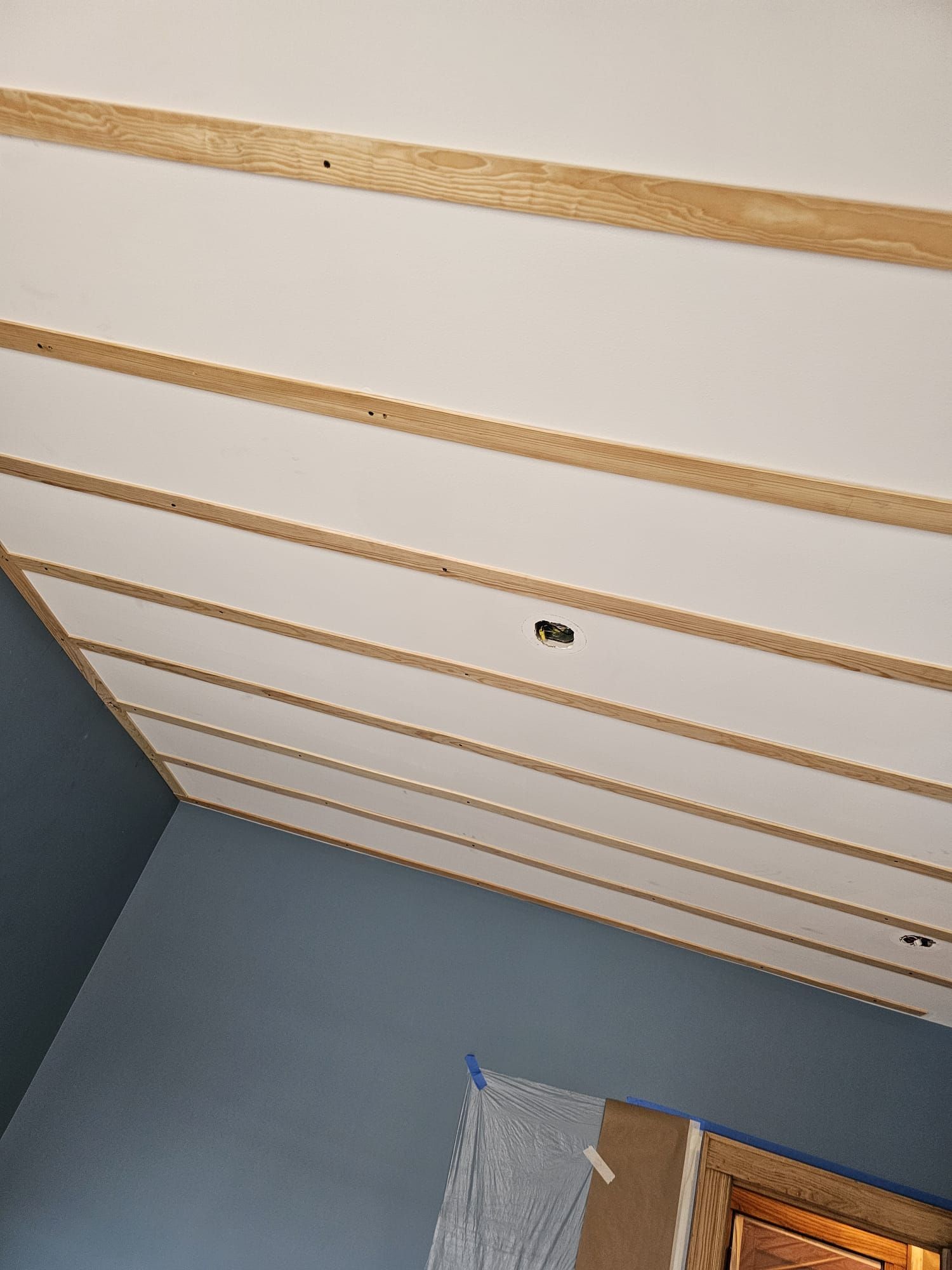 A room with a white ceiling and wooden beams