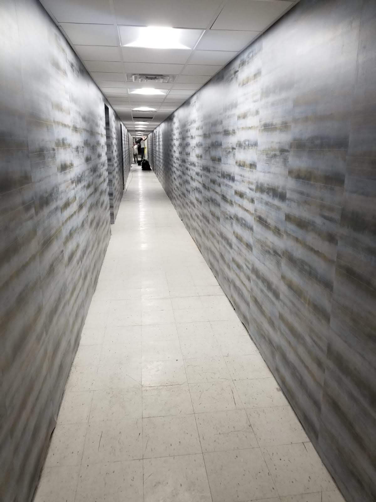 A long hallway with a person walking down it