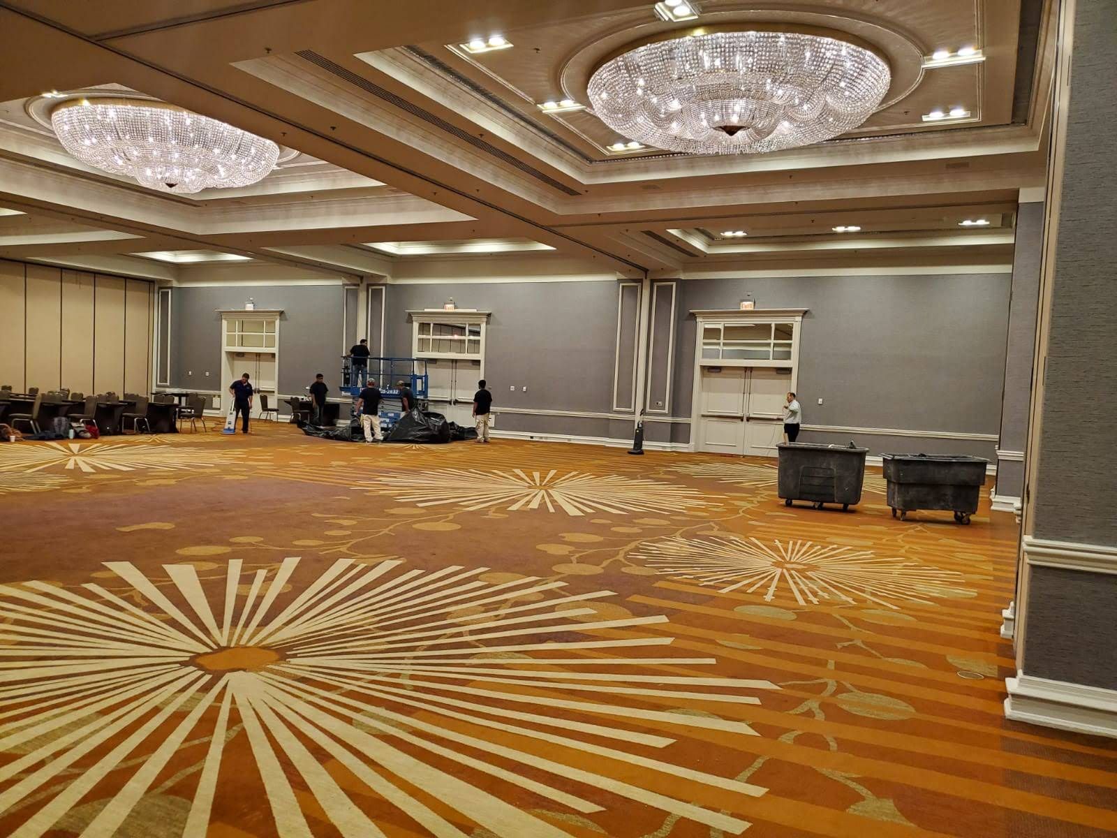 A large room with a chandelier and a circular pattern on the floor.