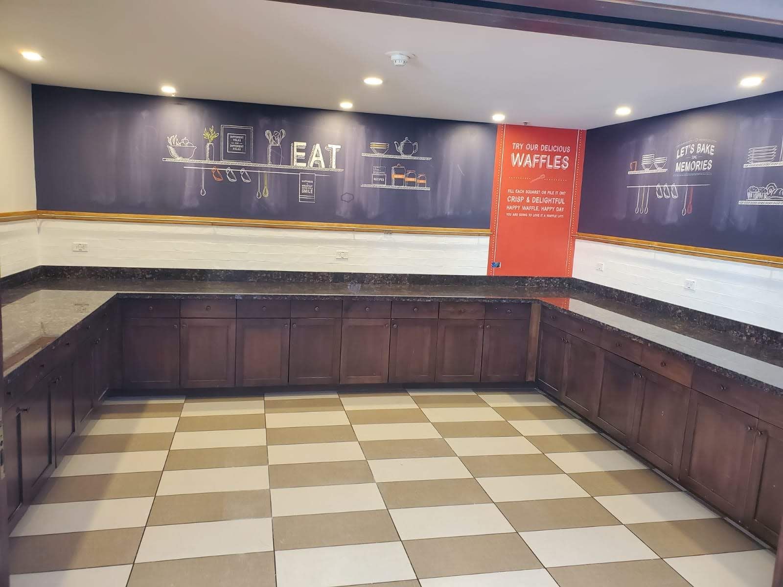 A kitchen with wooden cabinets and a checkered floor.