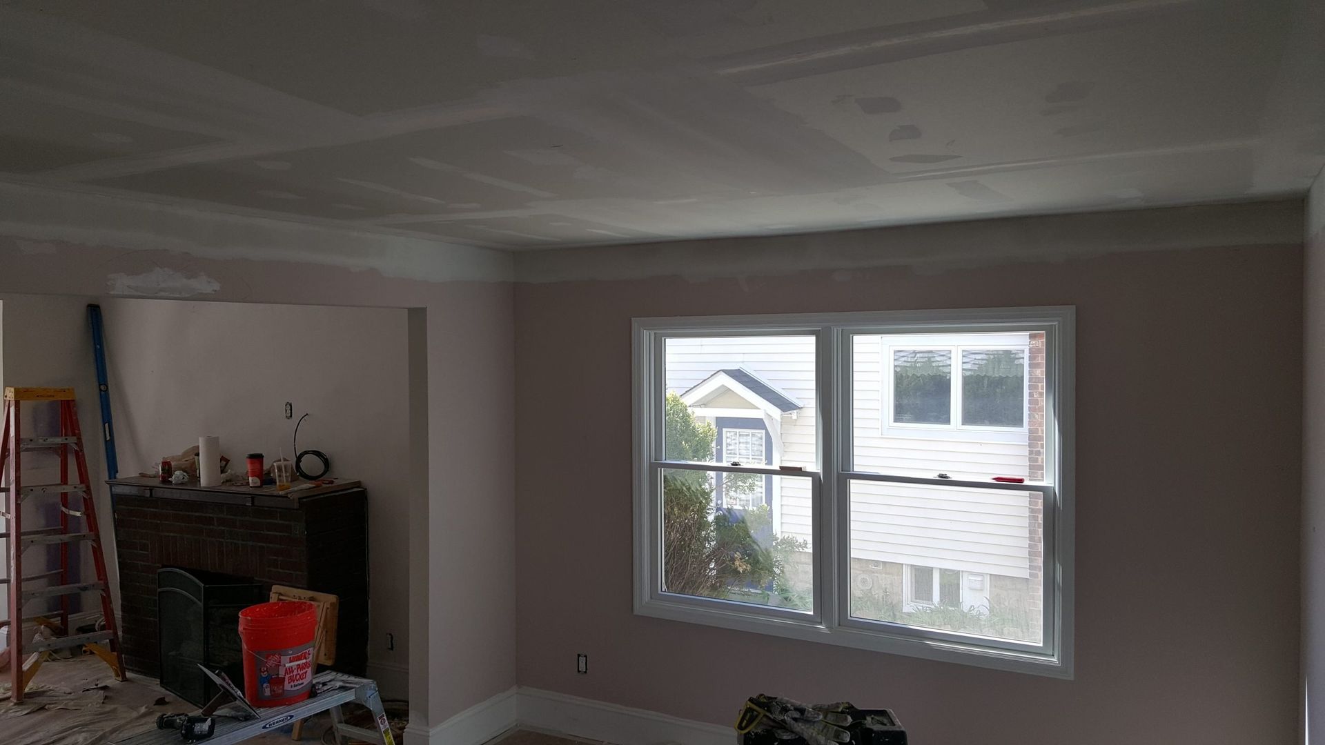A living room with two windows and a fireplace.