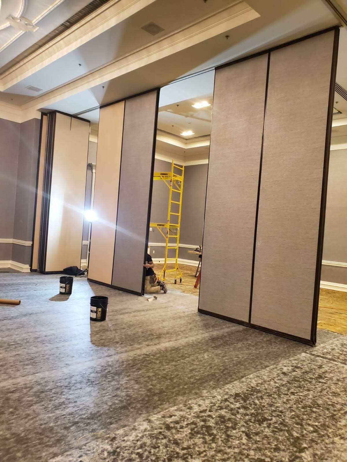 A large room with sliding walls and a yellow ladder.