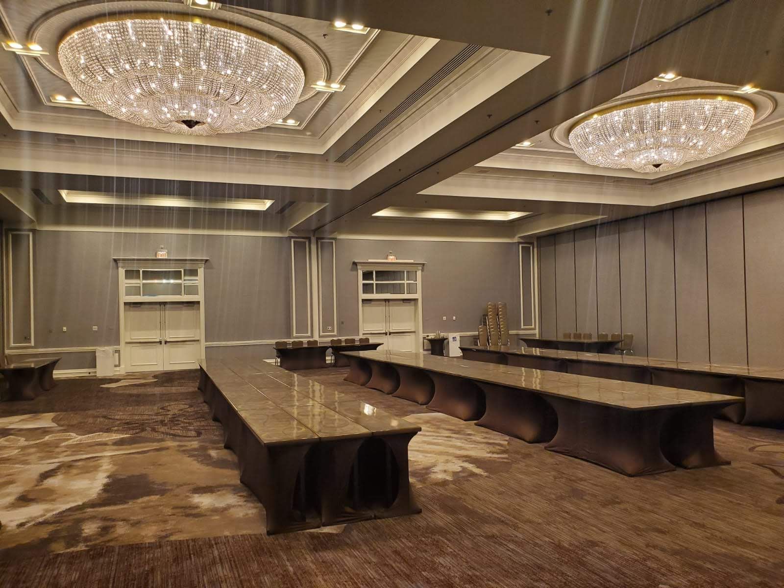 A large room with a lot of tables and chandeliers.