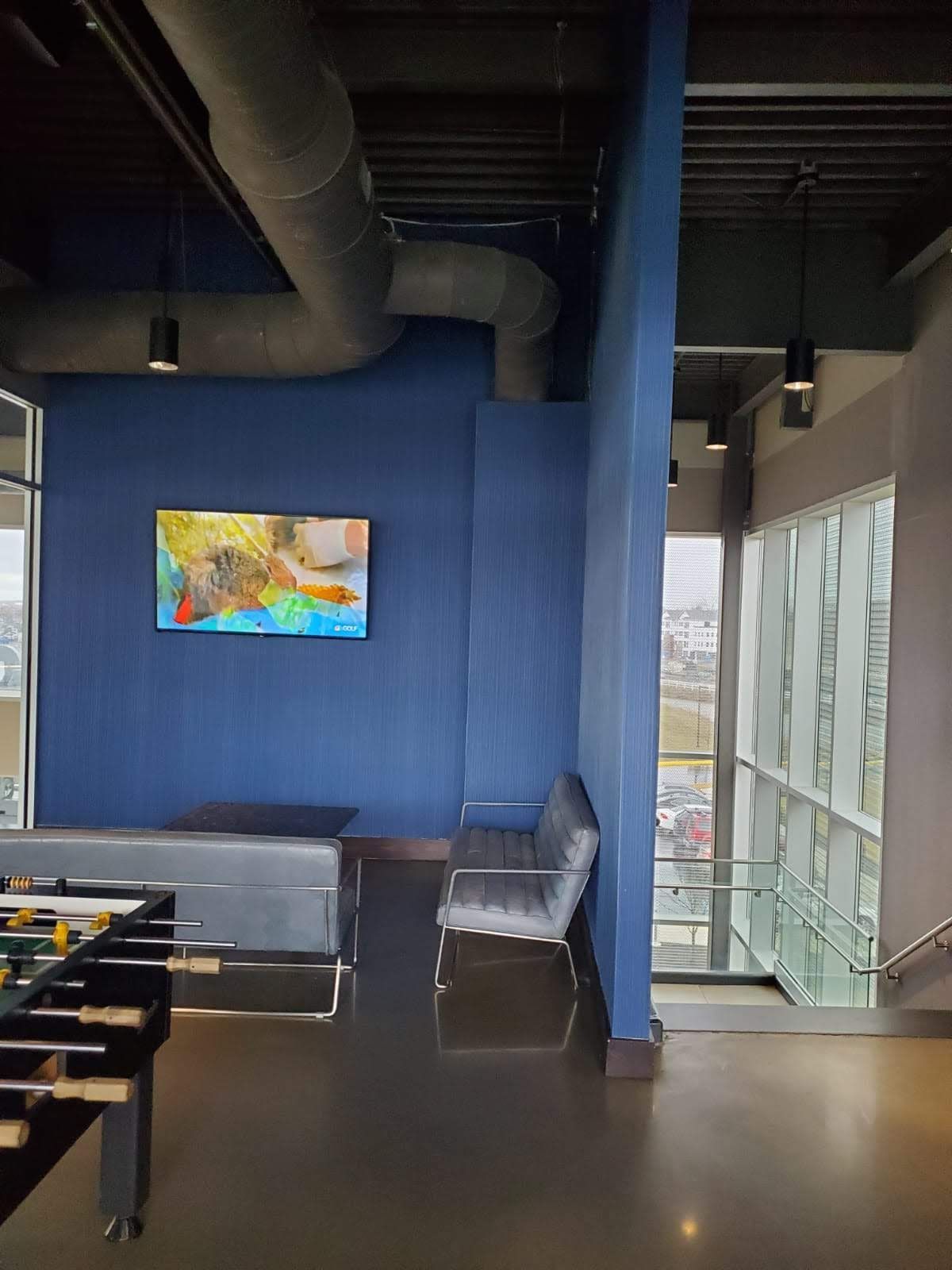 A room with a foosball table and a painting on the wall