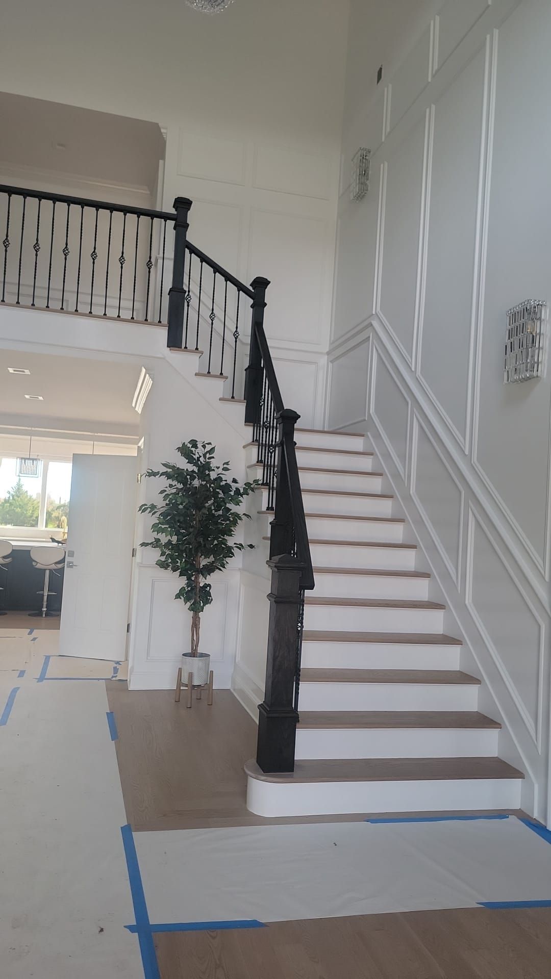 A staircase with white steps and a black railing in a house.