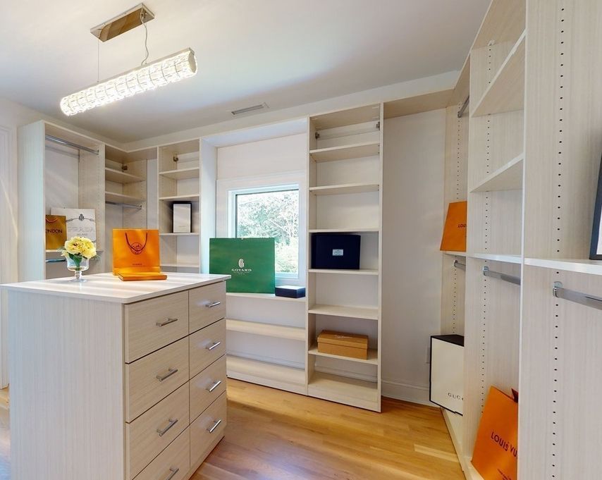 A walk in closet with lots of shelves and drawers