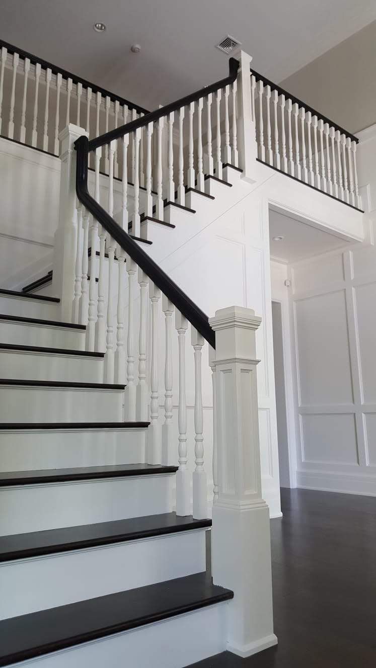 A white staircase with black steps and a black railing