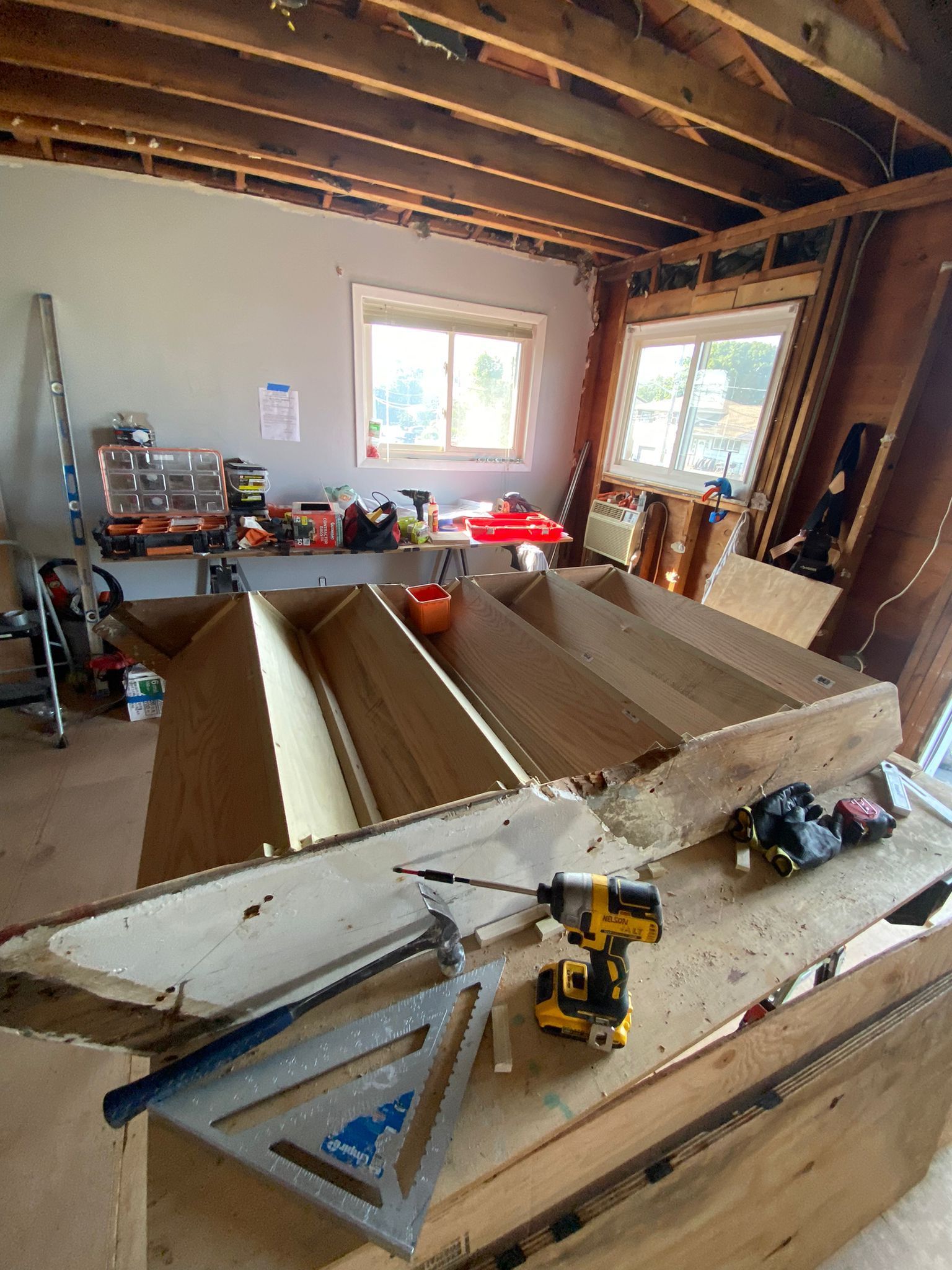 A wooden table with a drill on it in a room.